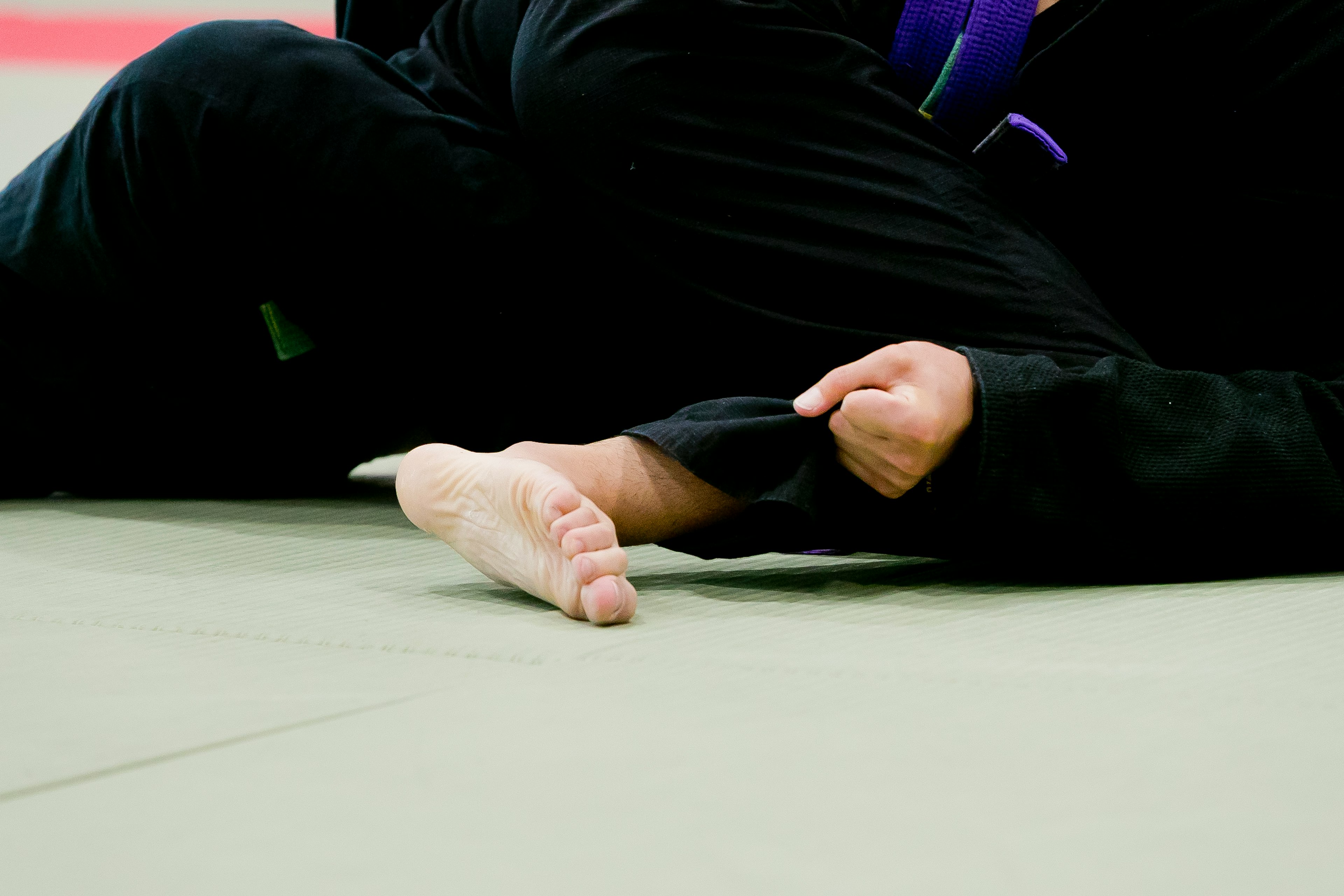 Primer plano de un pie y una mano durante un combate de judo