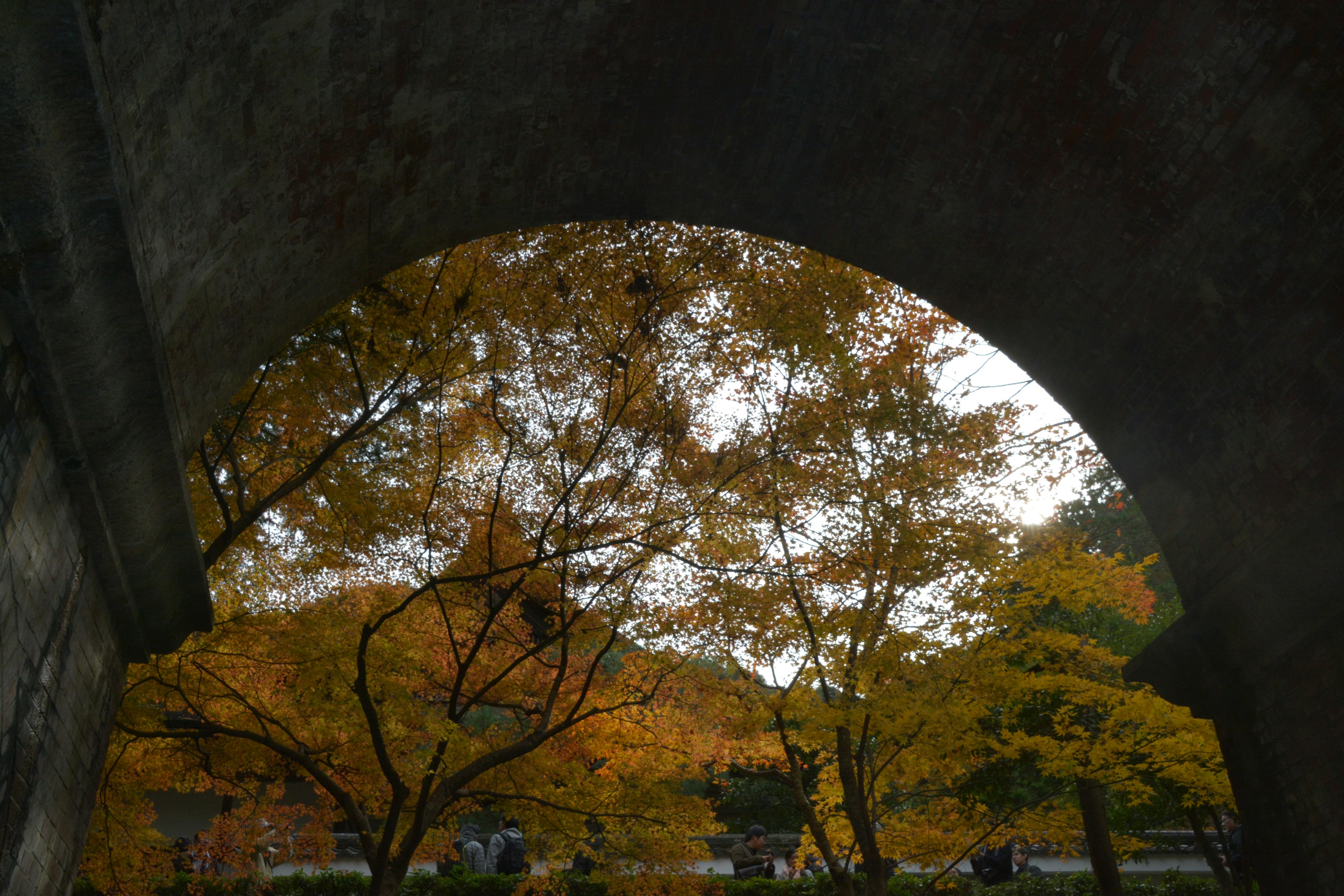 Vue de feuillage d'automne et silhouette de temple à travers une arche