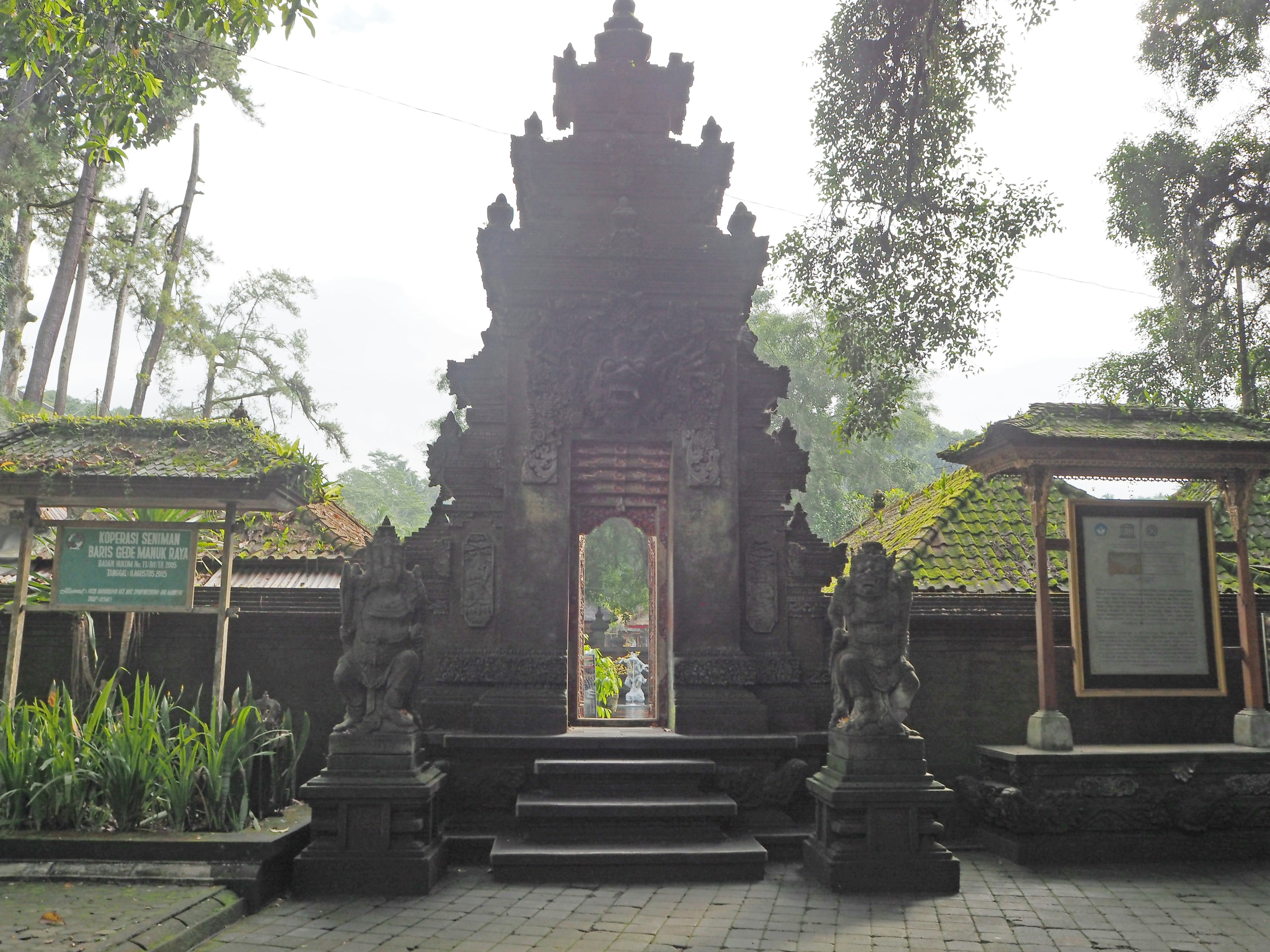 Traditional Balinese temple gate surrounded by greenery stone architecture