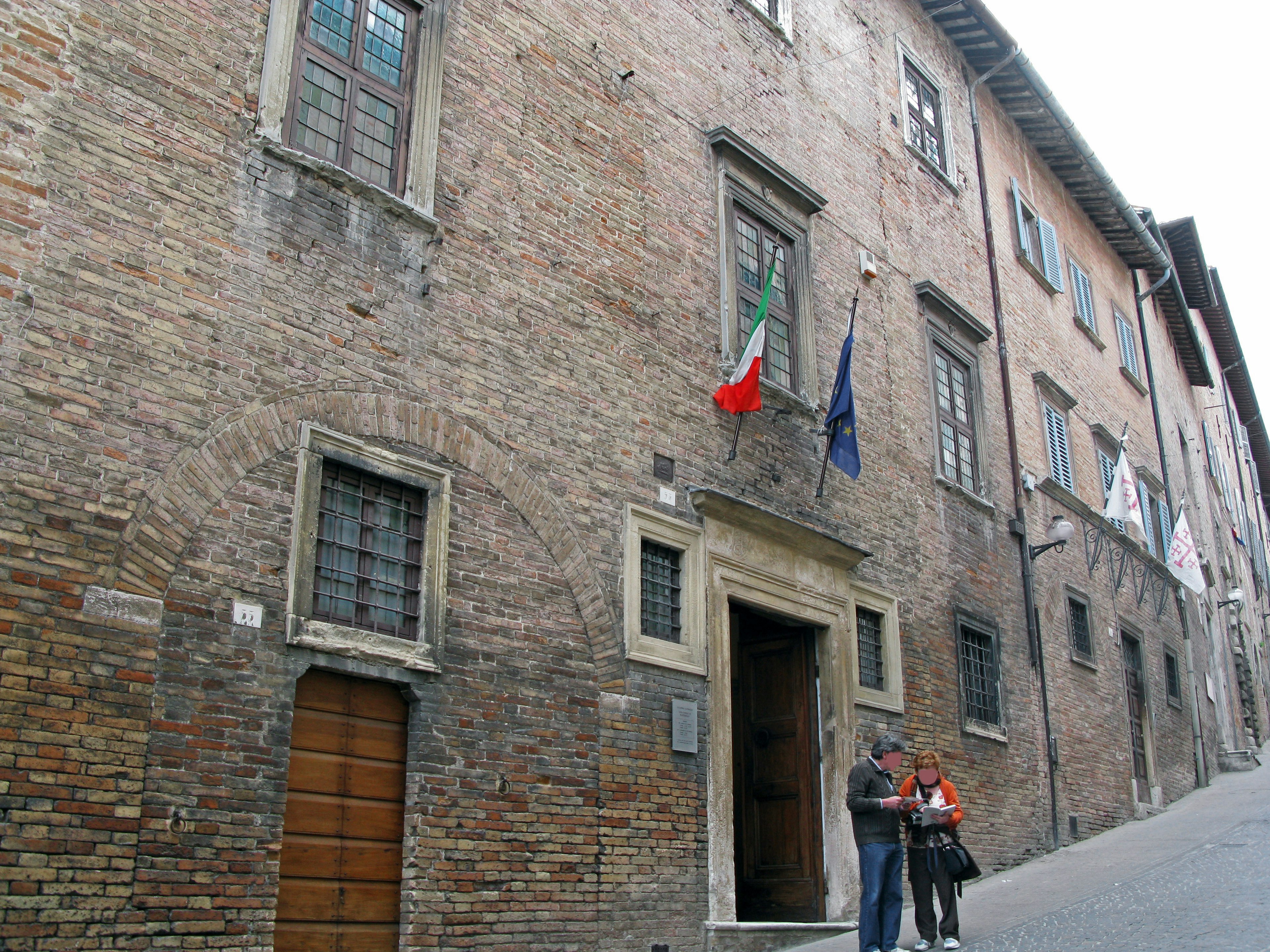 Antiguo edificio de ladrillo con dos personas afuera