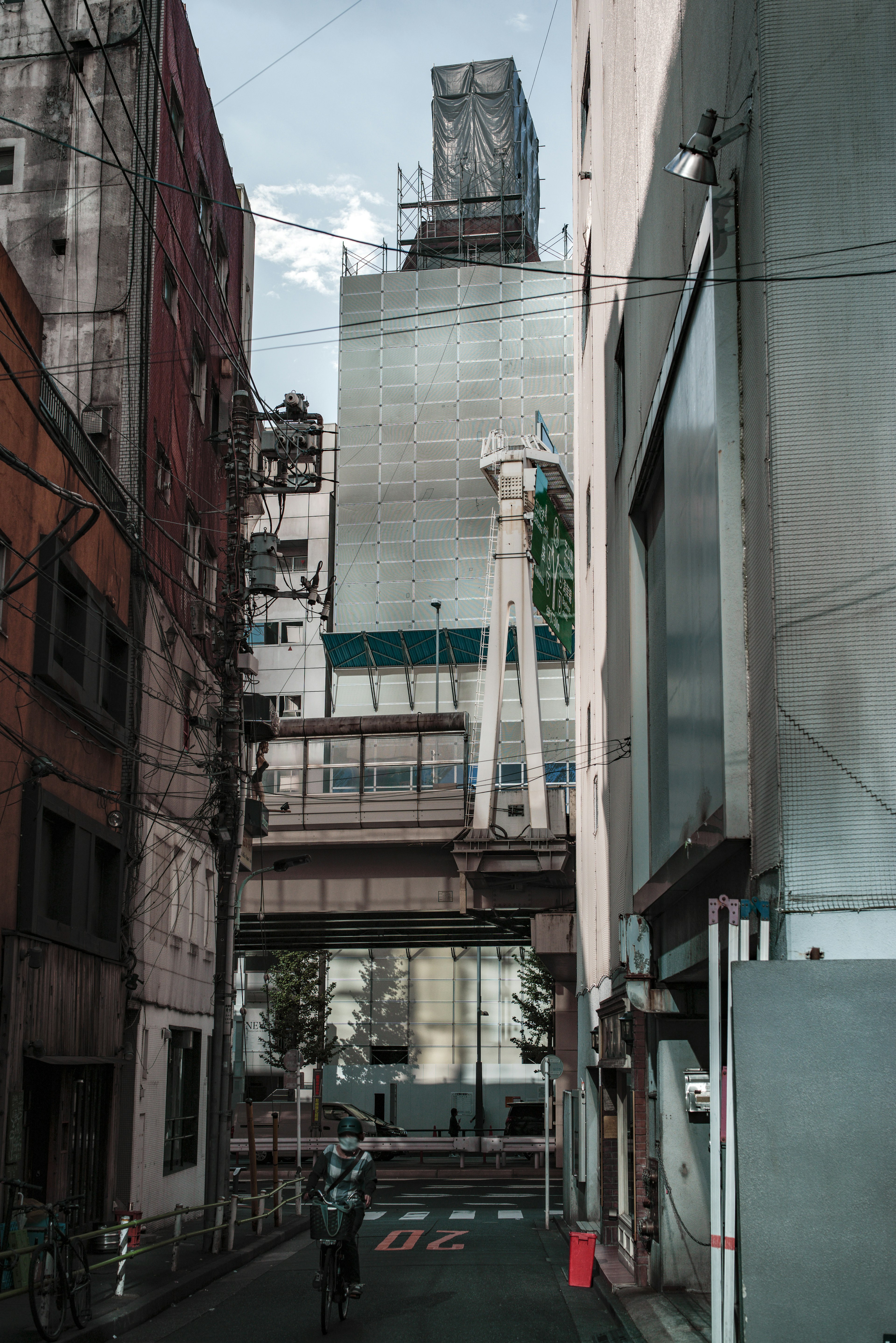 Contrast of buildings along a narrow street with a high-rise in the background