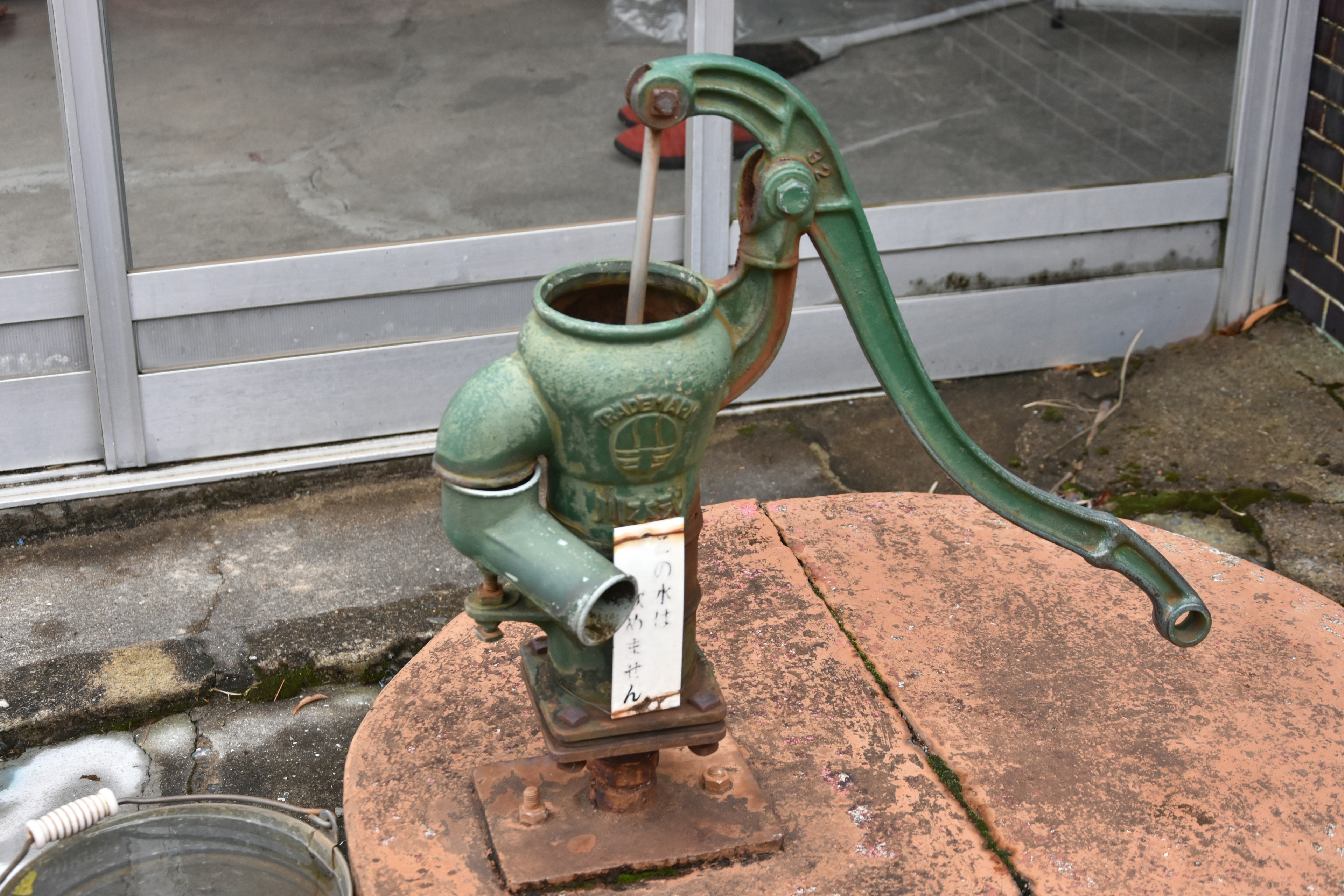 Old green pump placed on a rusty base