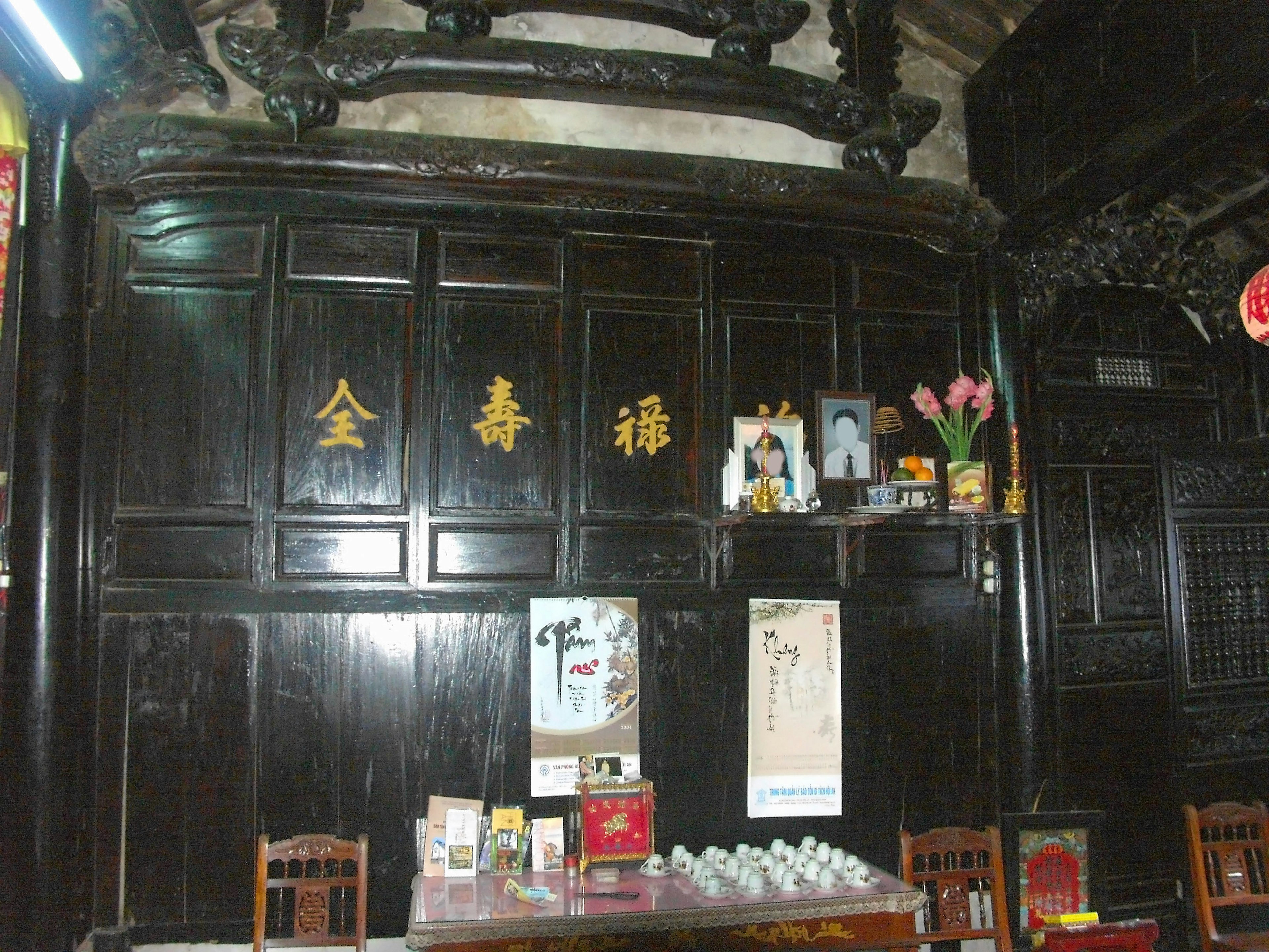 Intérieur chinois traditionnel avec mur en bois noir et caractères dorés