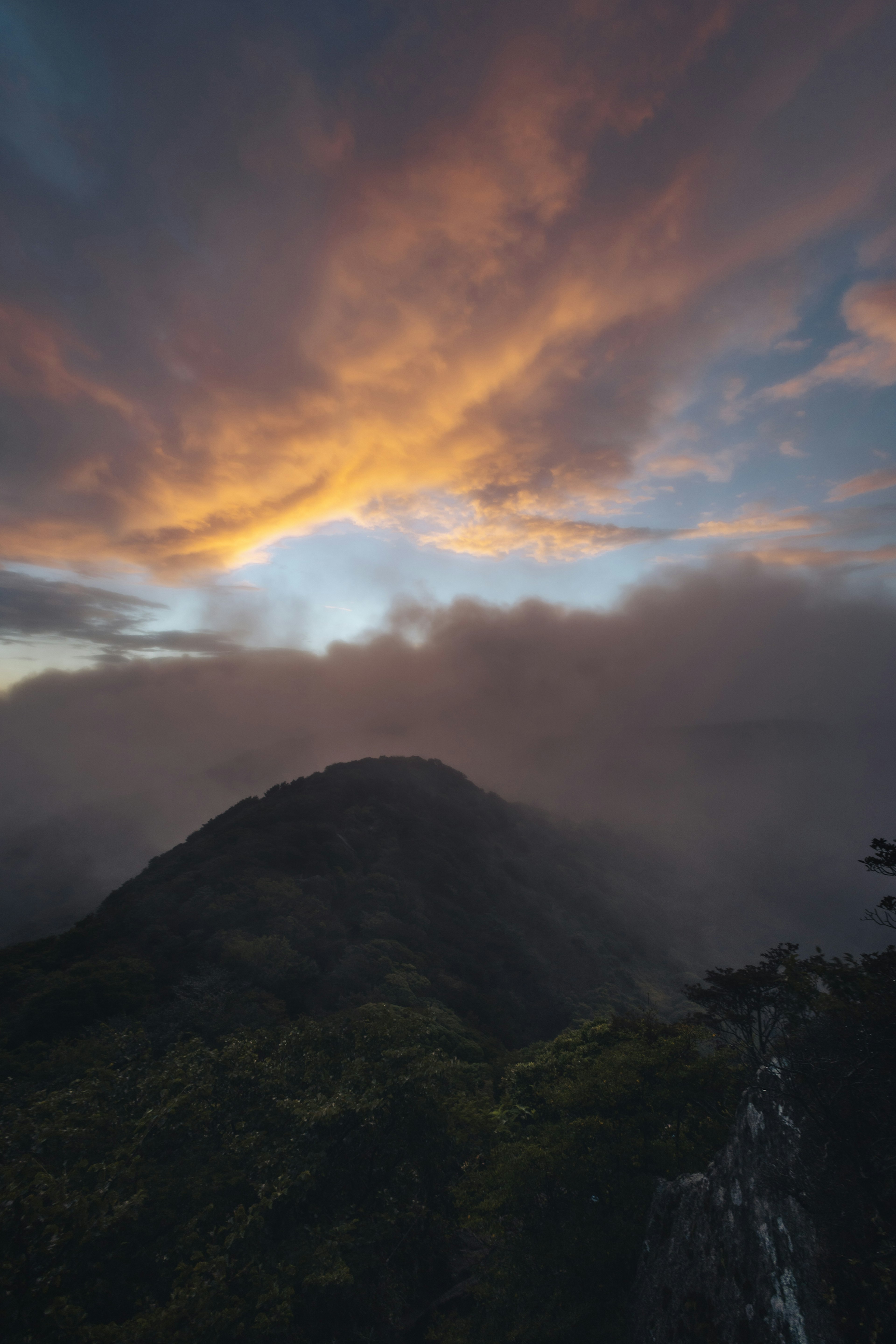 山の上に浮かぶ雲と夕焼けの空