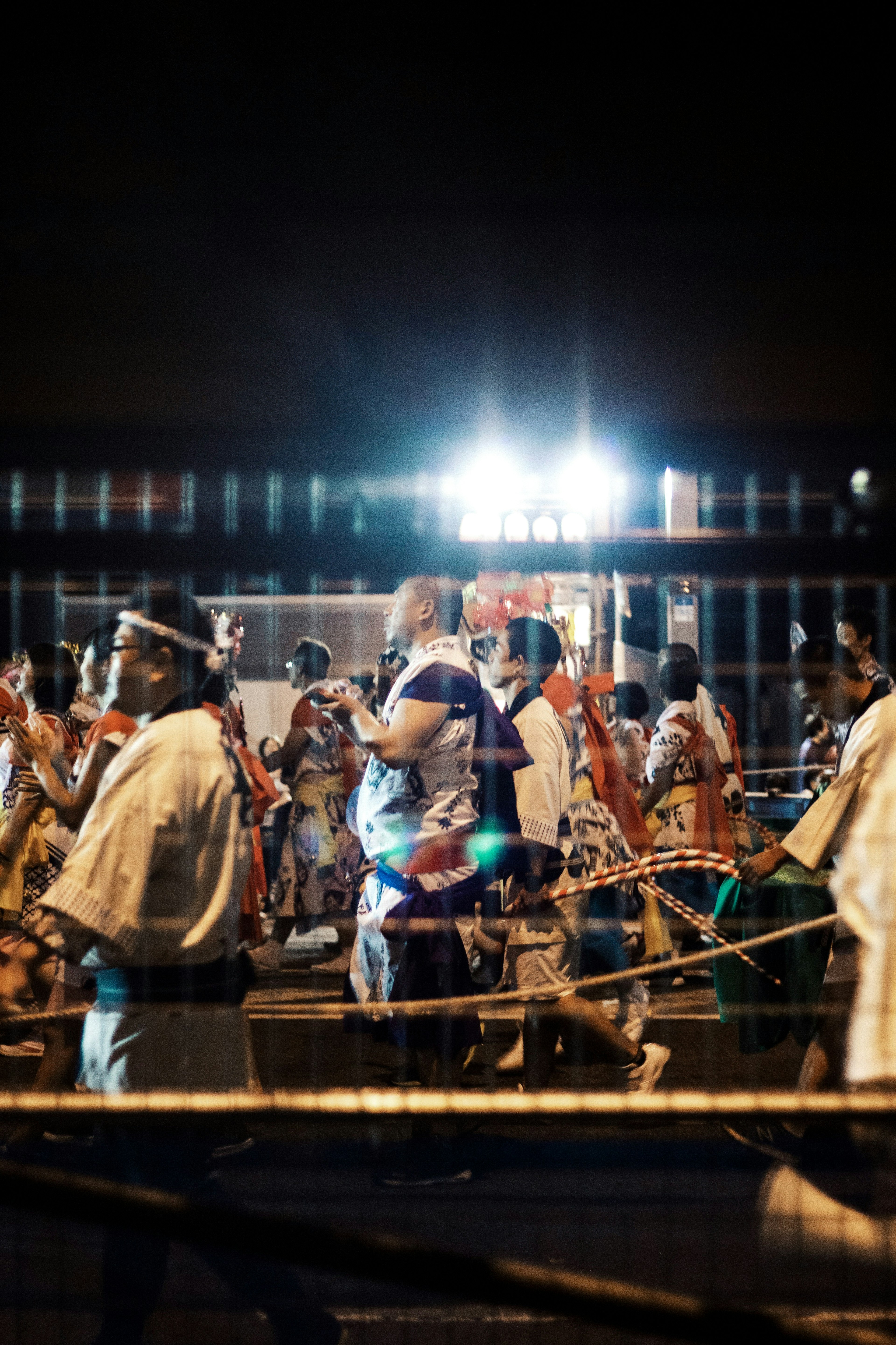 夜の祭りの行列で踊る人々が集まる光景