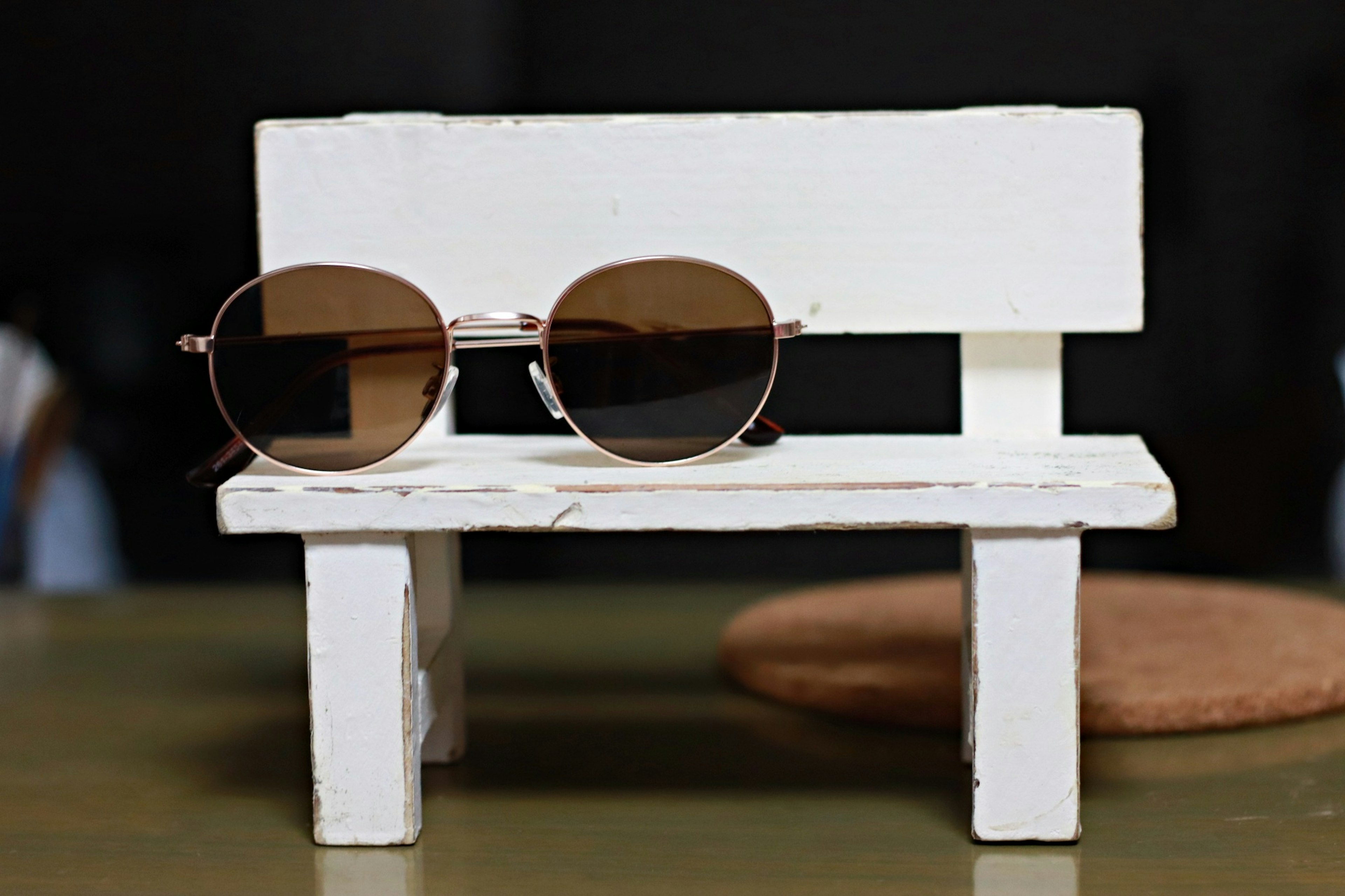 Photo of sunglasses on a small white bench