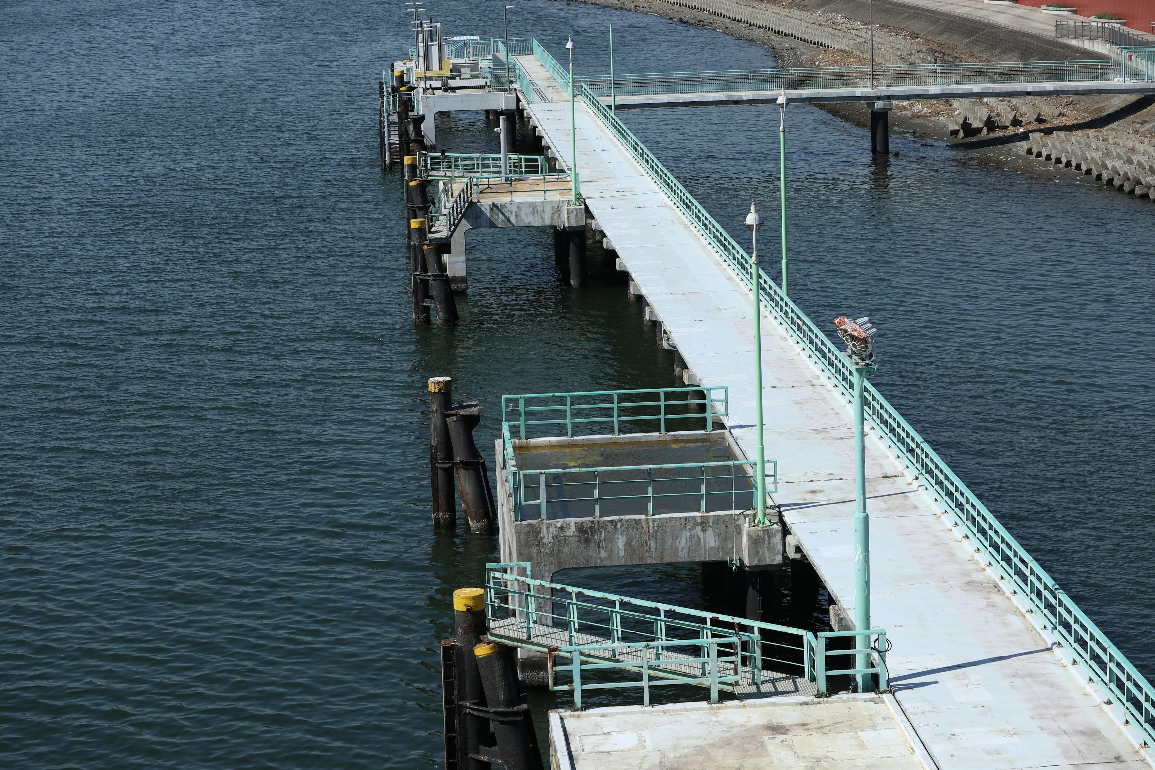 Pemandangan dermaga di atas air dengan elemen struktural