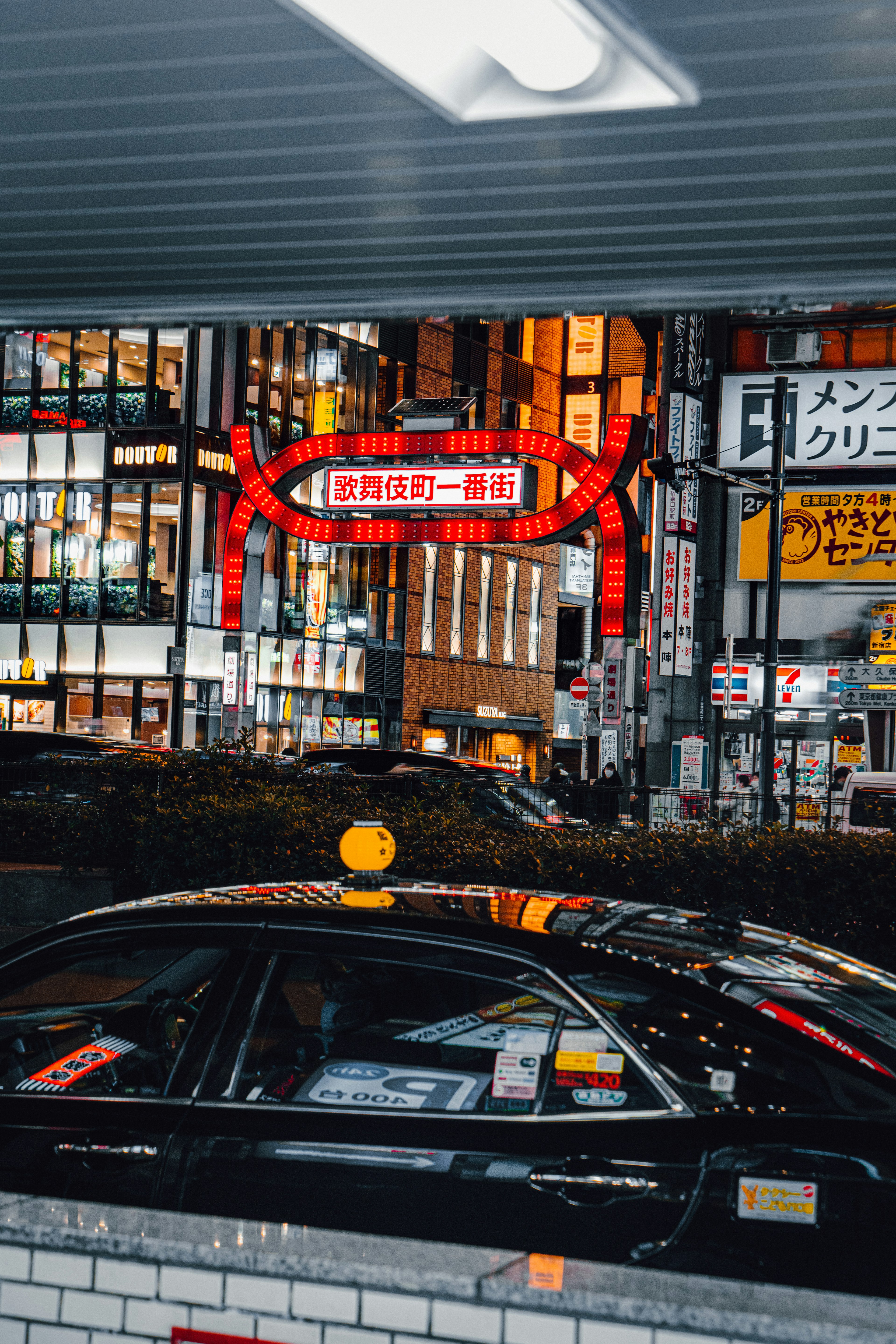 Paesaggio urbano notturno con un taxi e insegne al neon