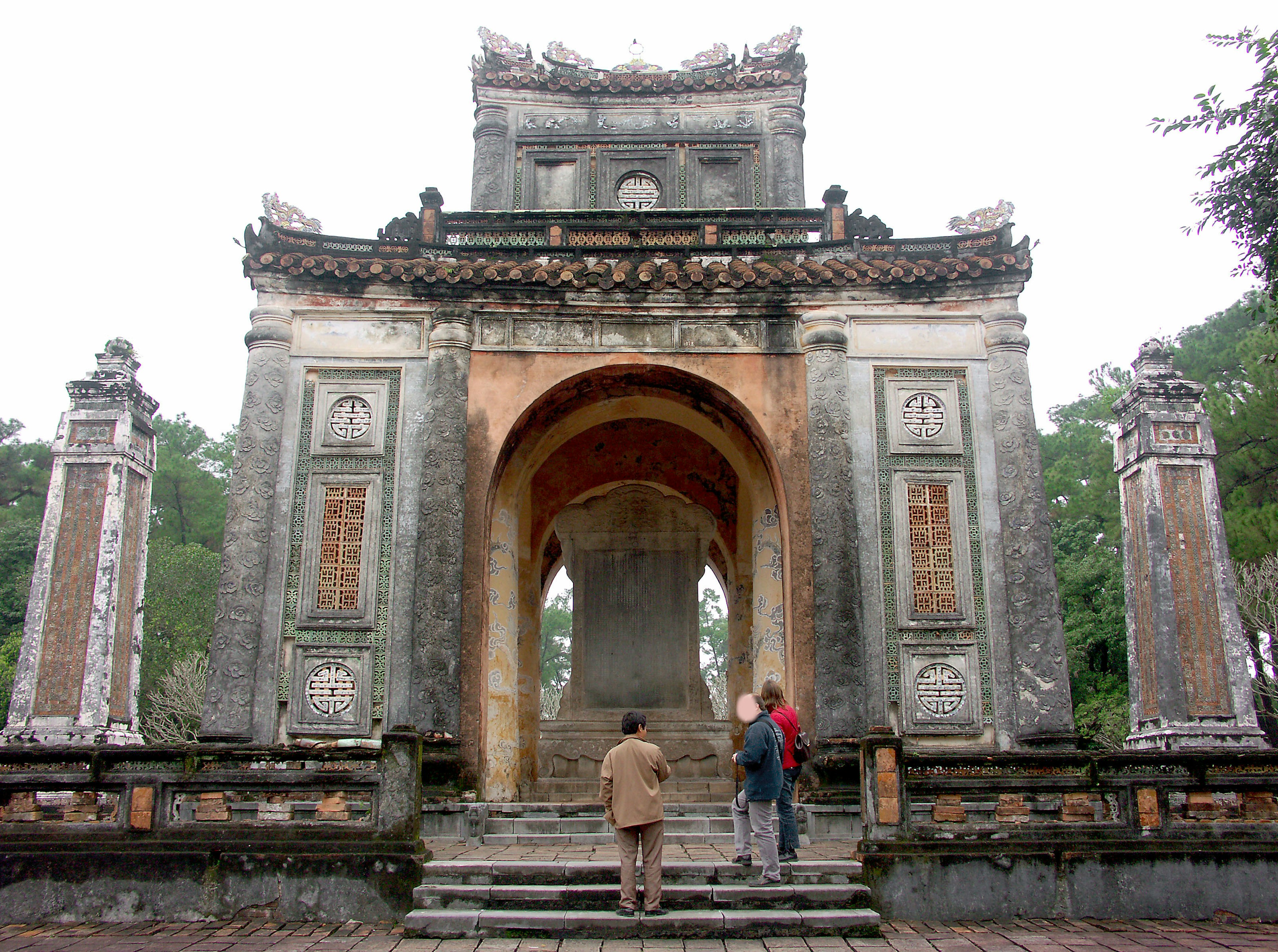 People walking towards a historic gate with intricate designs