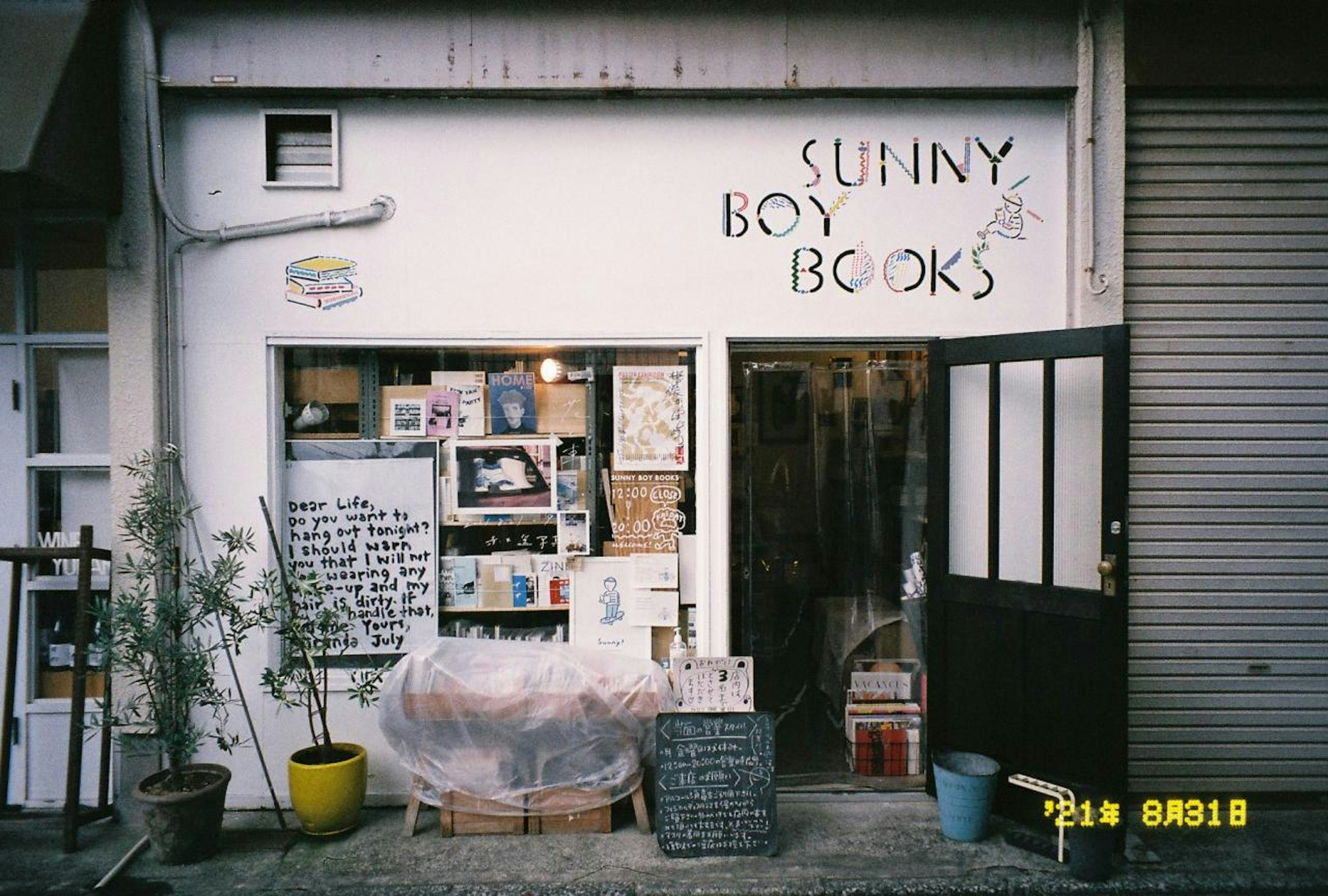 Extérieur de Sunny Boy Books petite librairie avec divers présentoirs de livres