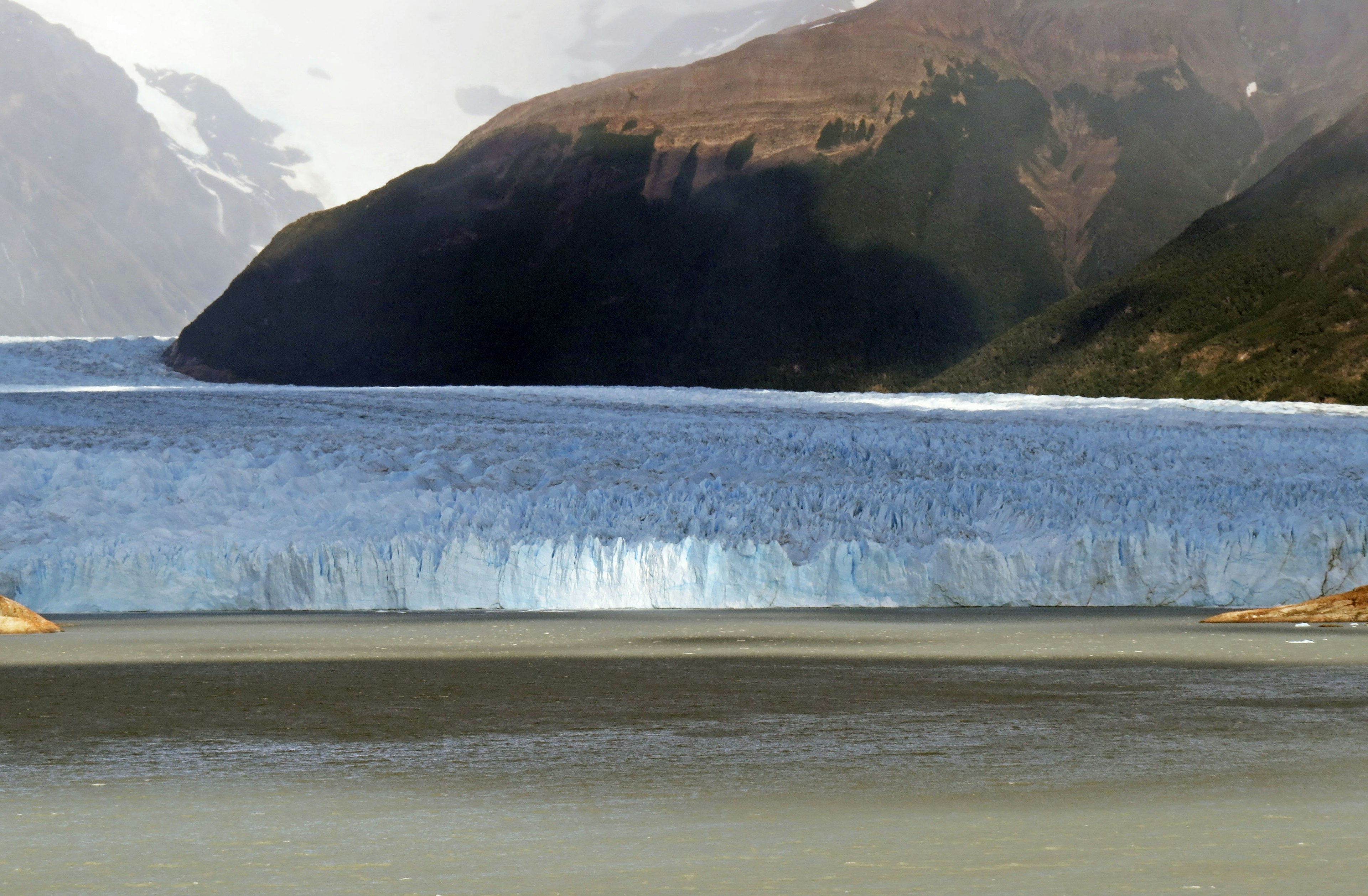 Beautiful landscape of a glacier flowing into a lake surrounded by mountains