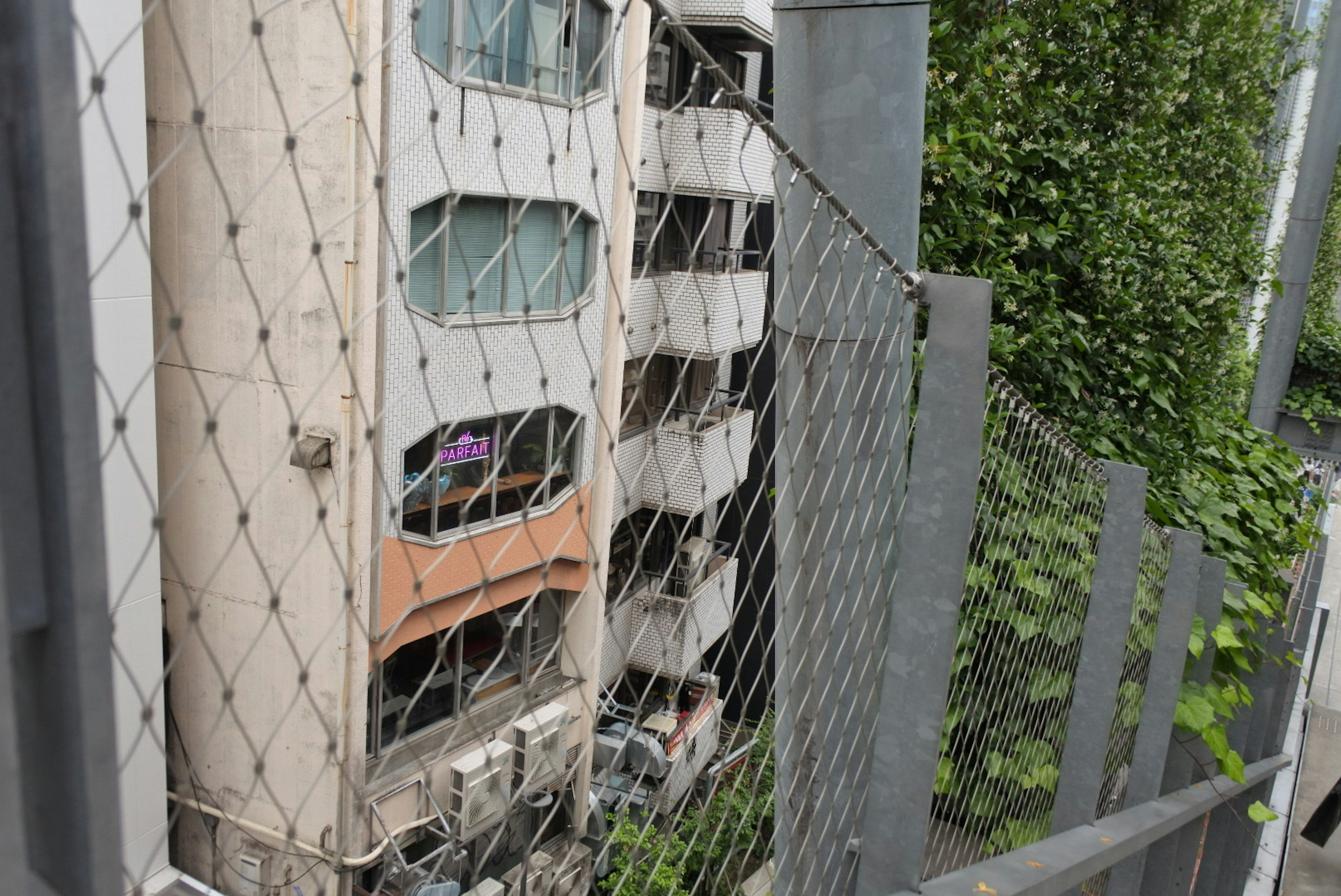 Un edificio antiguo rodeado por una red con vegetación alrededor