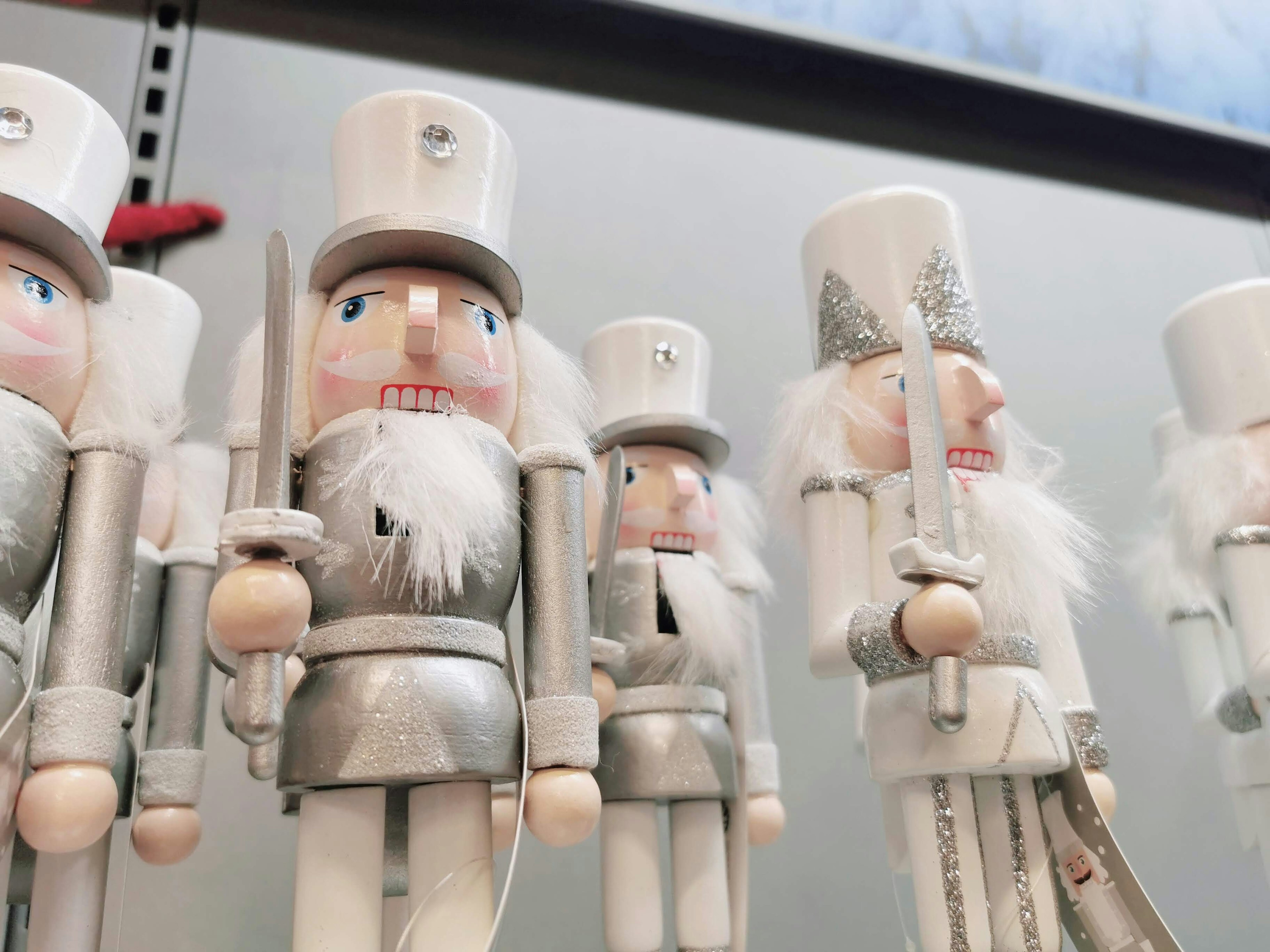 Wooden nutcracker figurines dressed in silver are lined up