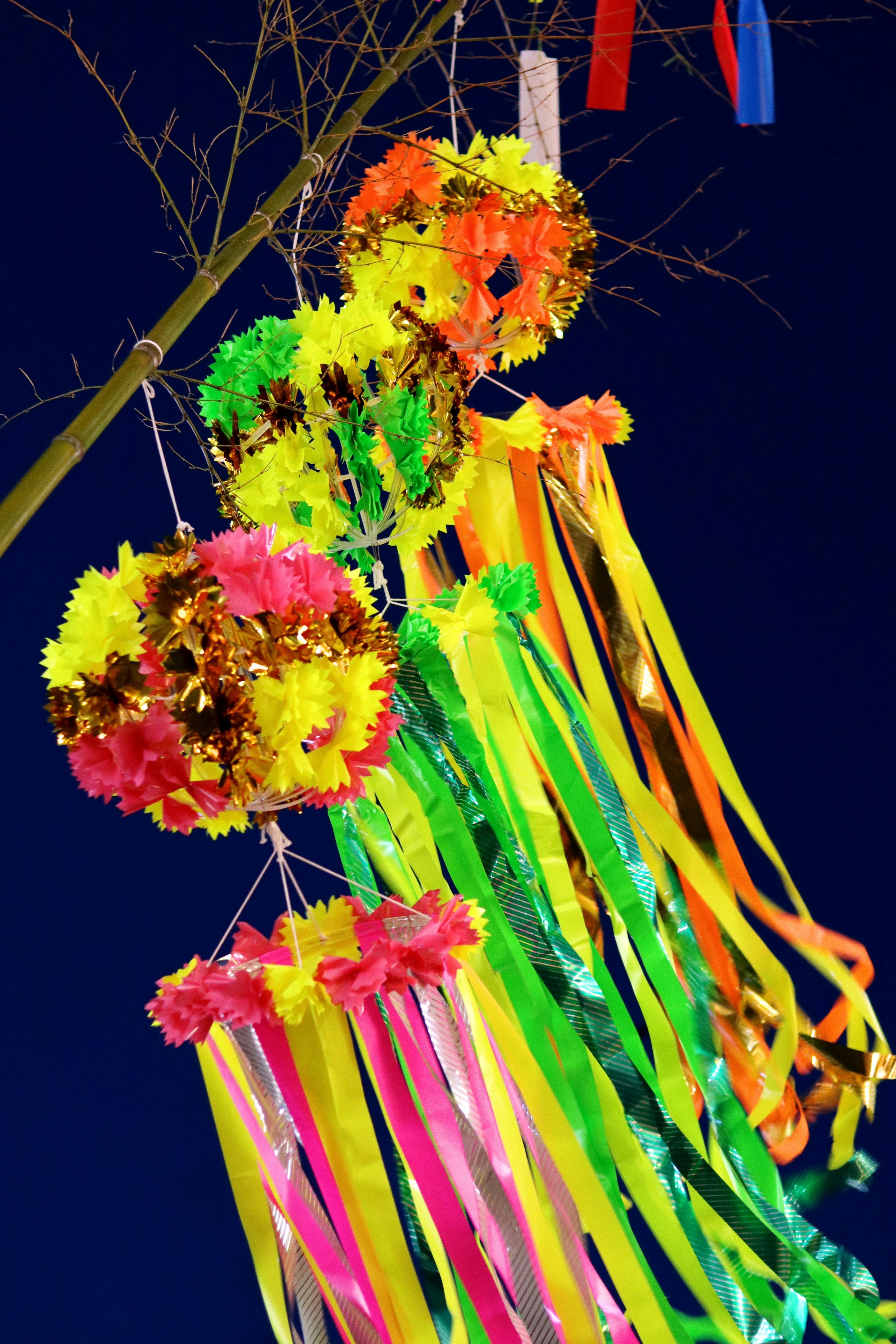 Bunte Dekorationen mit Blumen und Bändern, die von einem Baum hängen