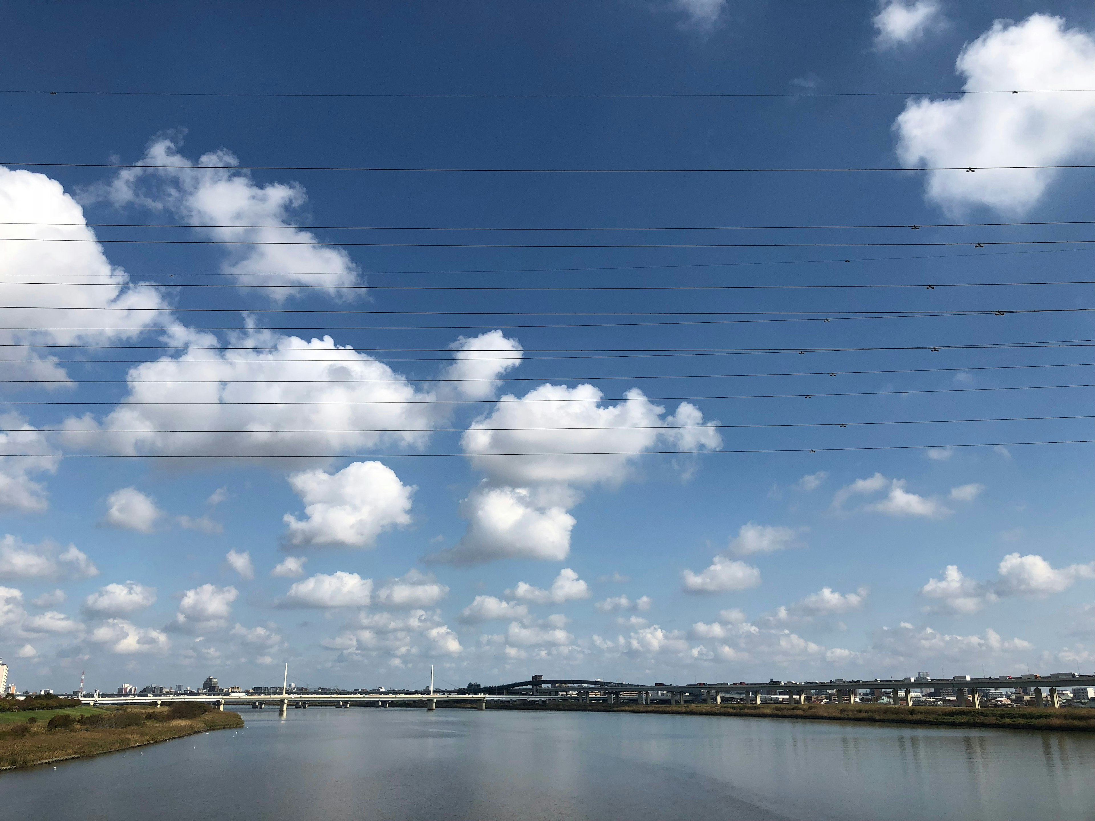 青空と白い雲が広がる川の風景