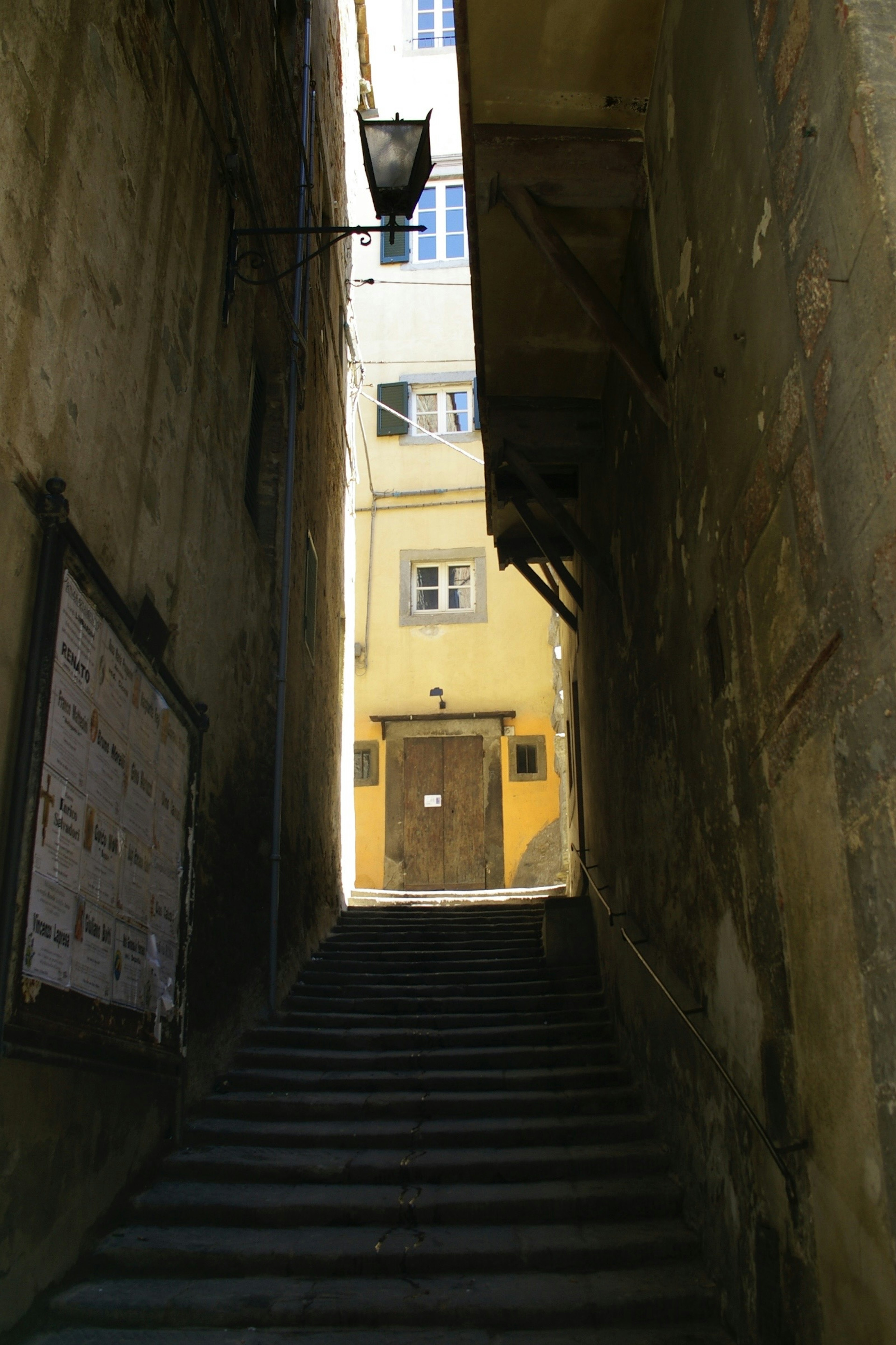 Foto einer engen Straße mit Treppen Alte Gebäude flankieren den schwach beleuchteten Weg