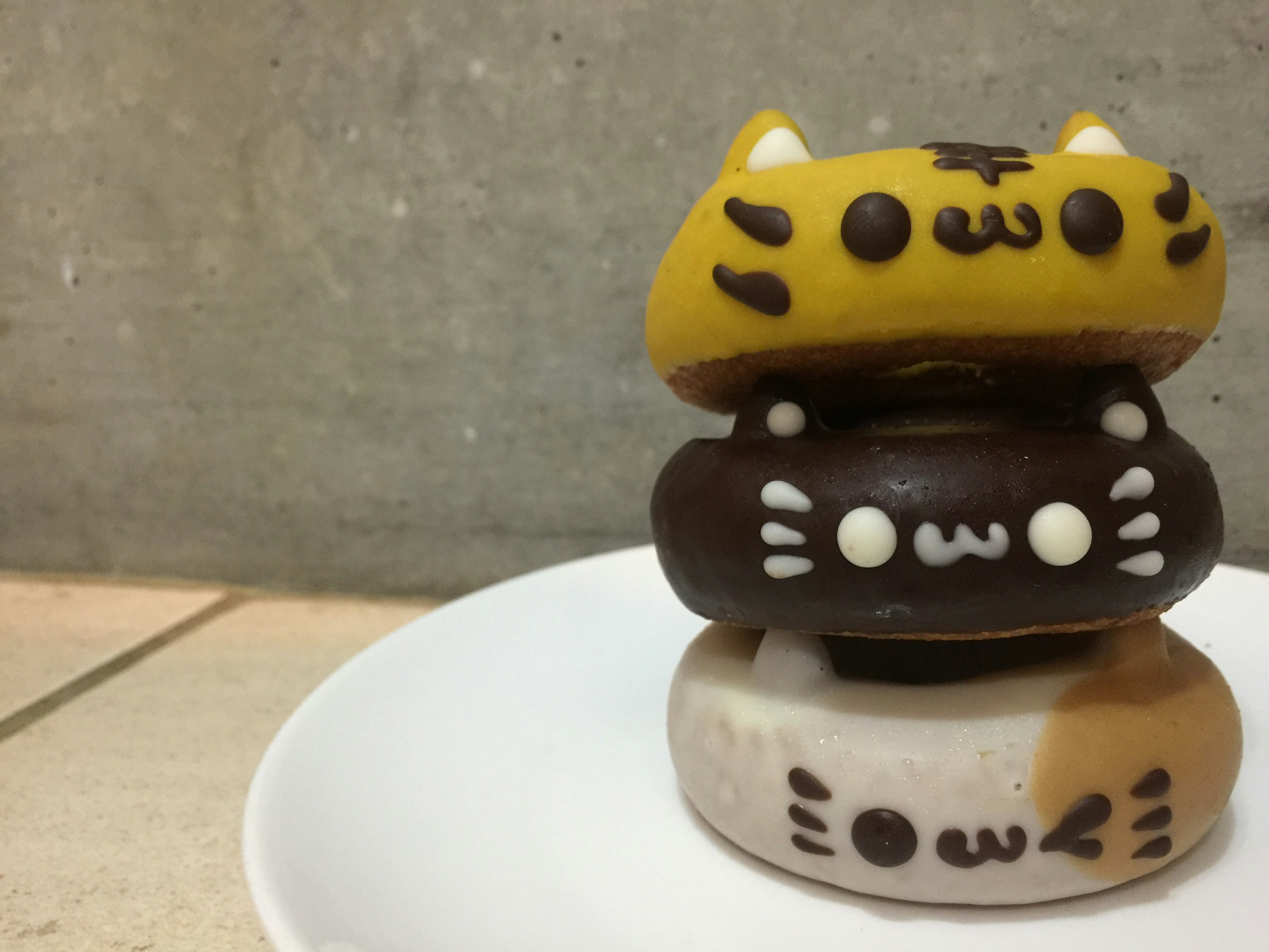 Tres donuts de tema gato apilados en un plato