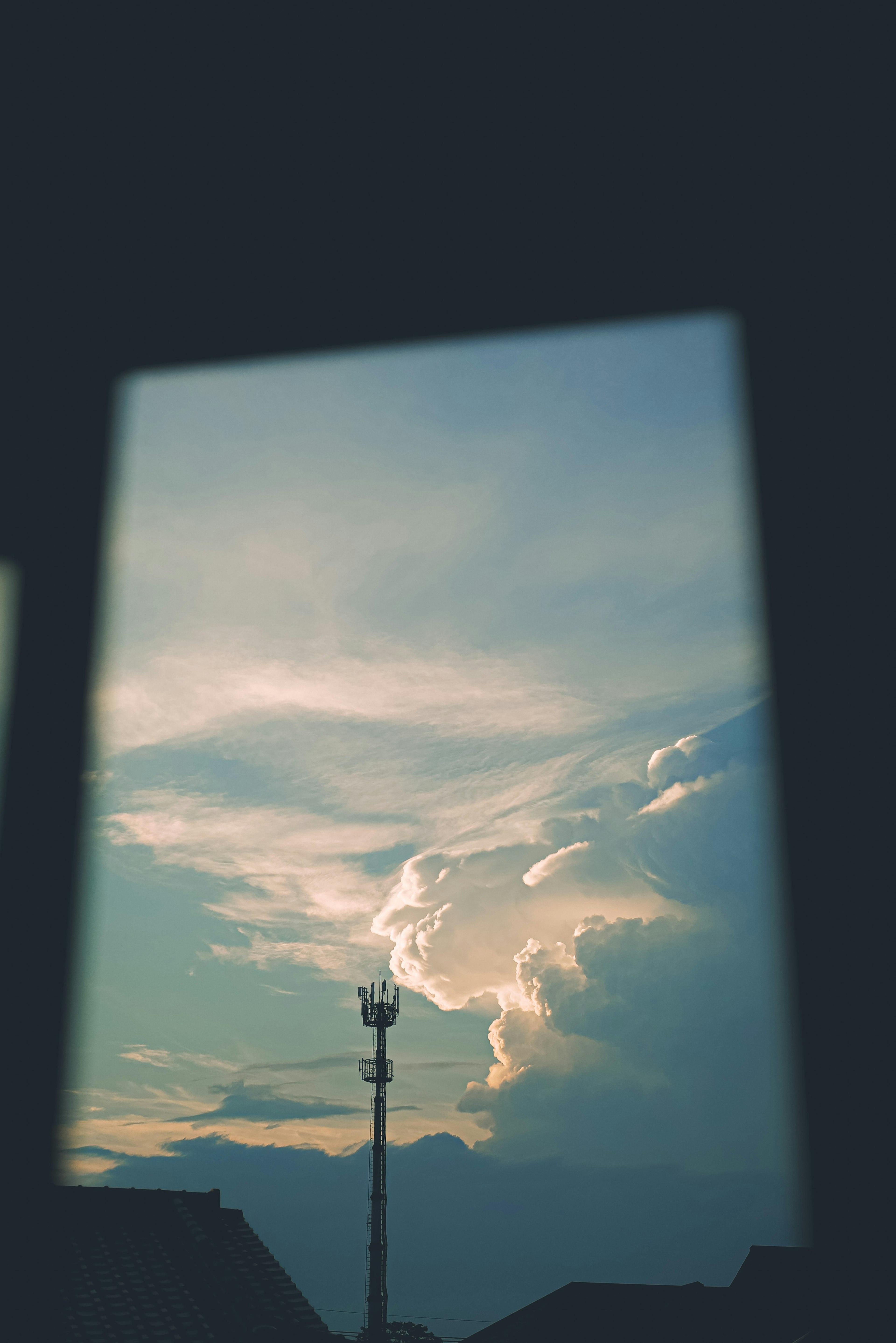 Blick auf den blauen Himmel und die weißen Wolken durch ein Fenster Sanfte Beleuchtung mit einem nahegelegenen Strommast