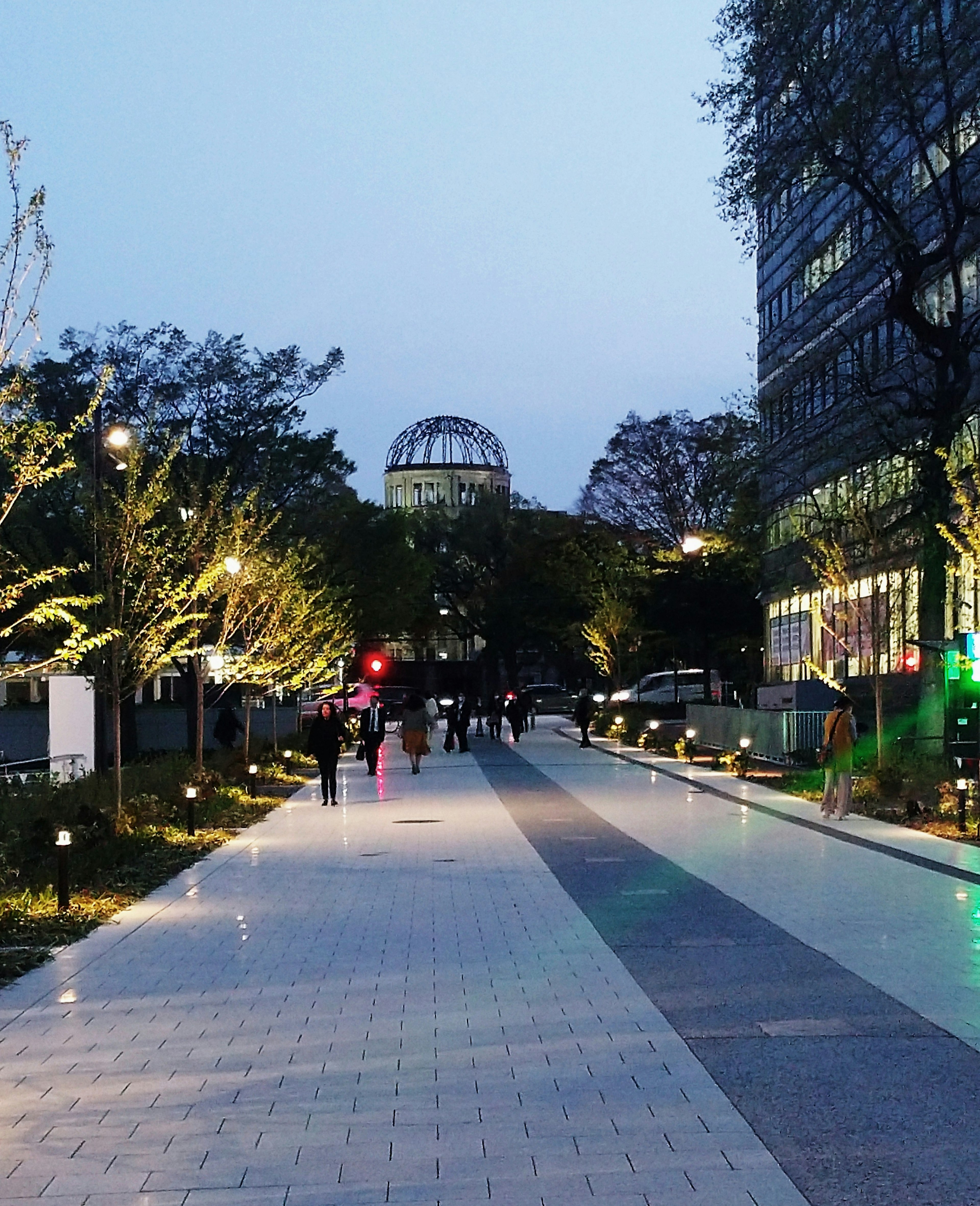 夜の街道に沿った歩行者と街灯の風景