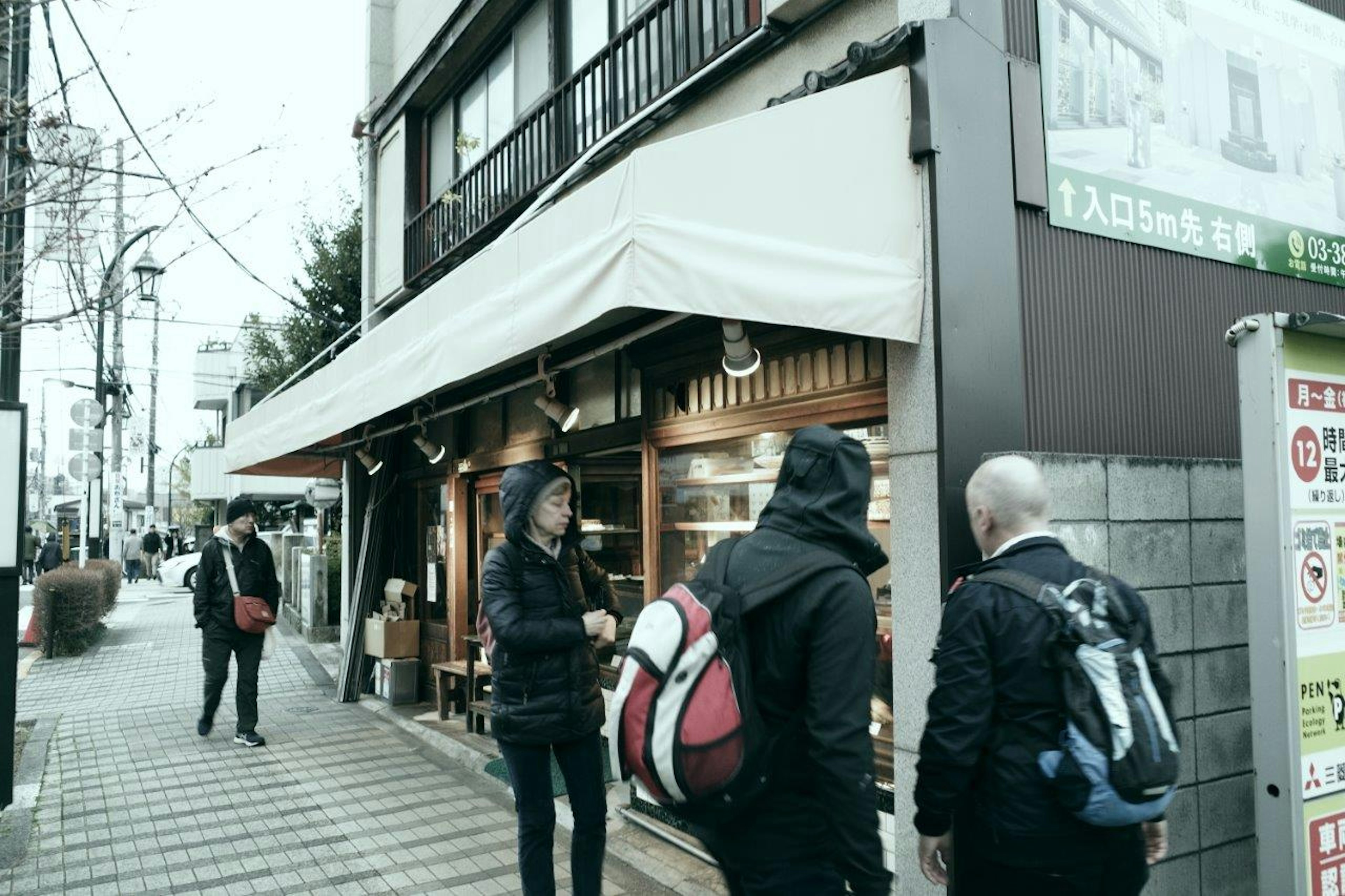 Persone in piedi davanti a un negozio nella scena di strada di Tokyo