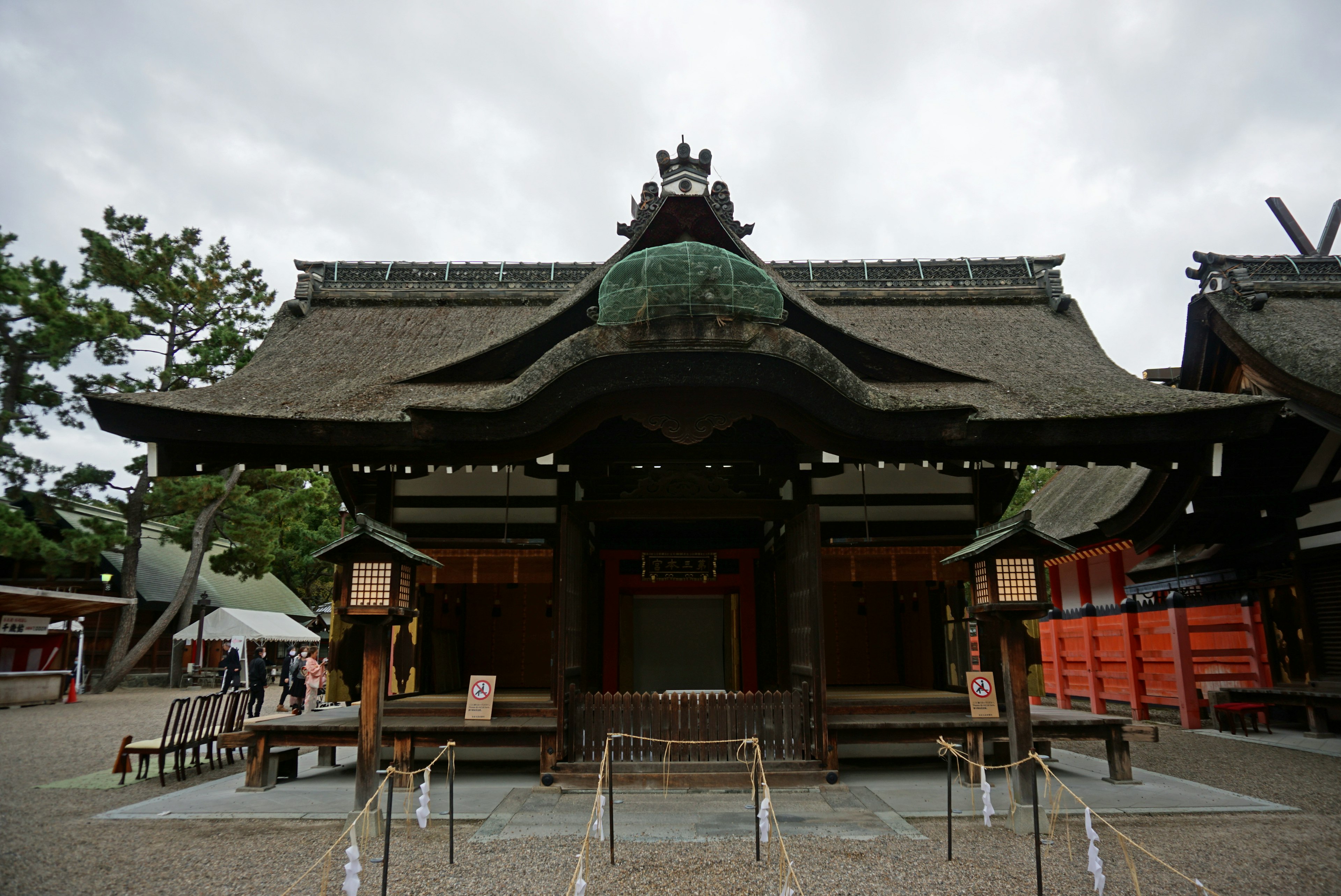 伝統的な日本の神社の建物が見える緑色の屋根と木製の構造