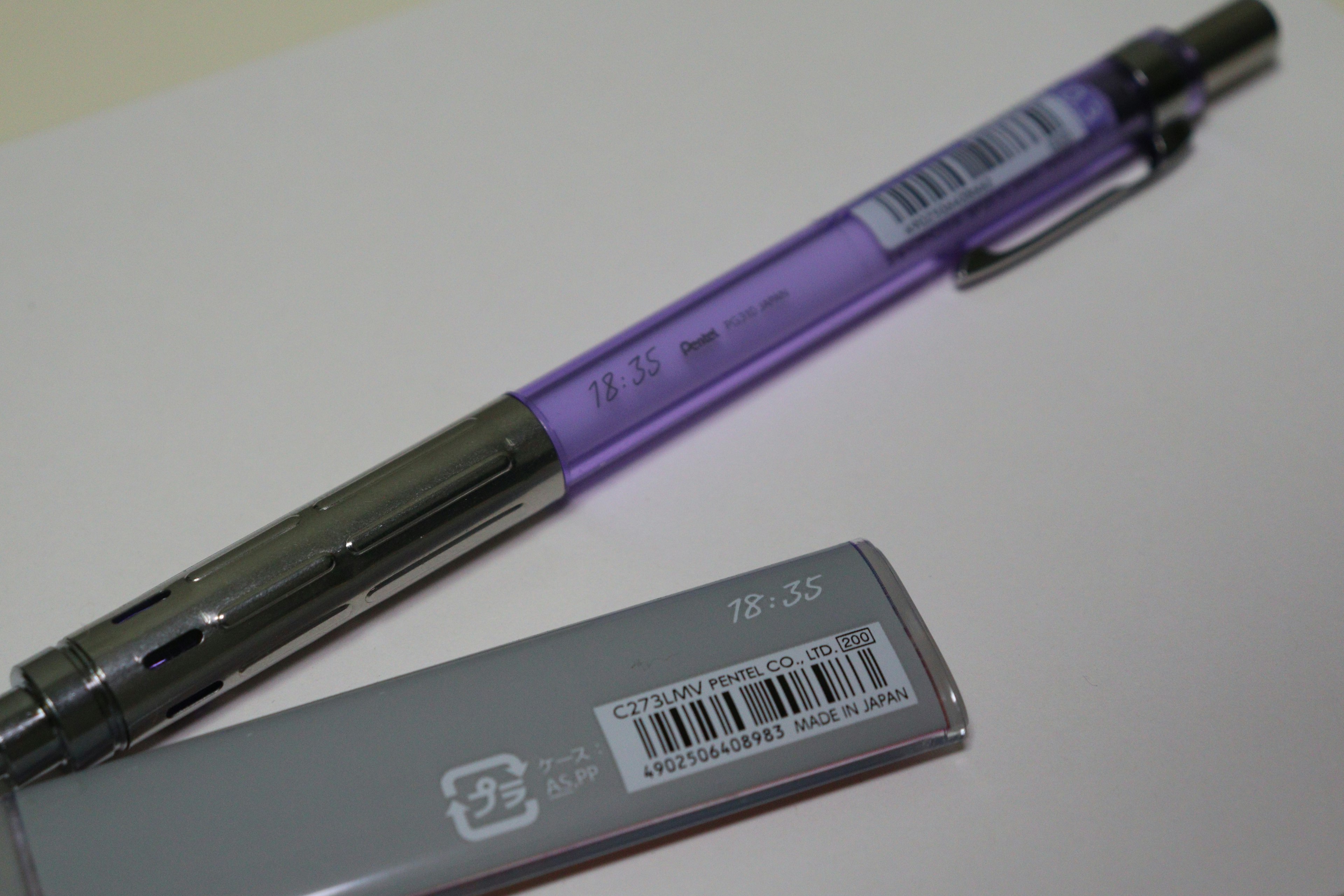 Stylo violet et gomme grise sur fond blanc