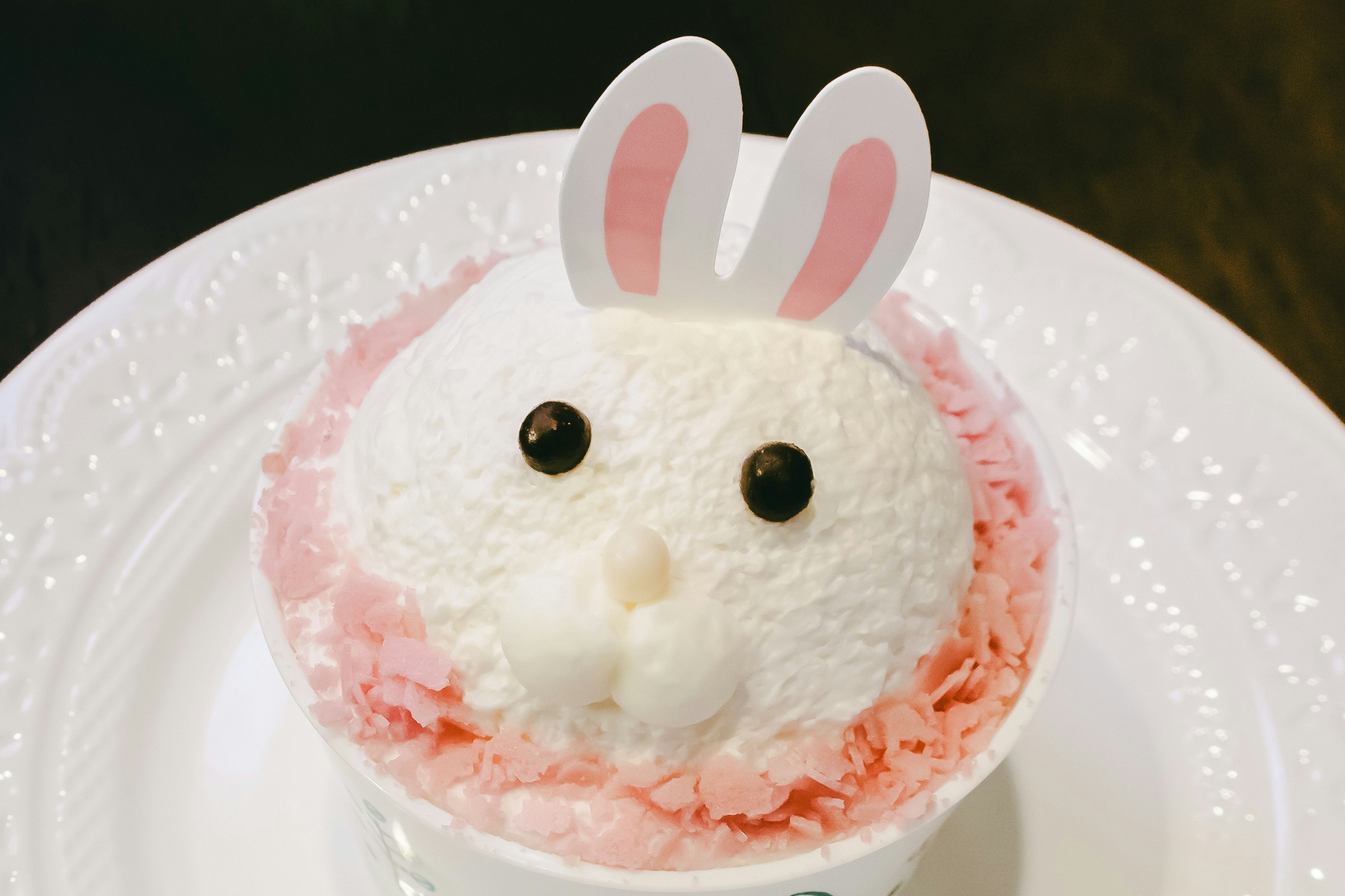 Dessert de glace en forme de lapin avec de la glace blanche et rose et des oreilles de lapin