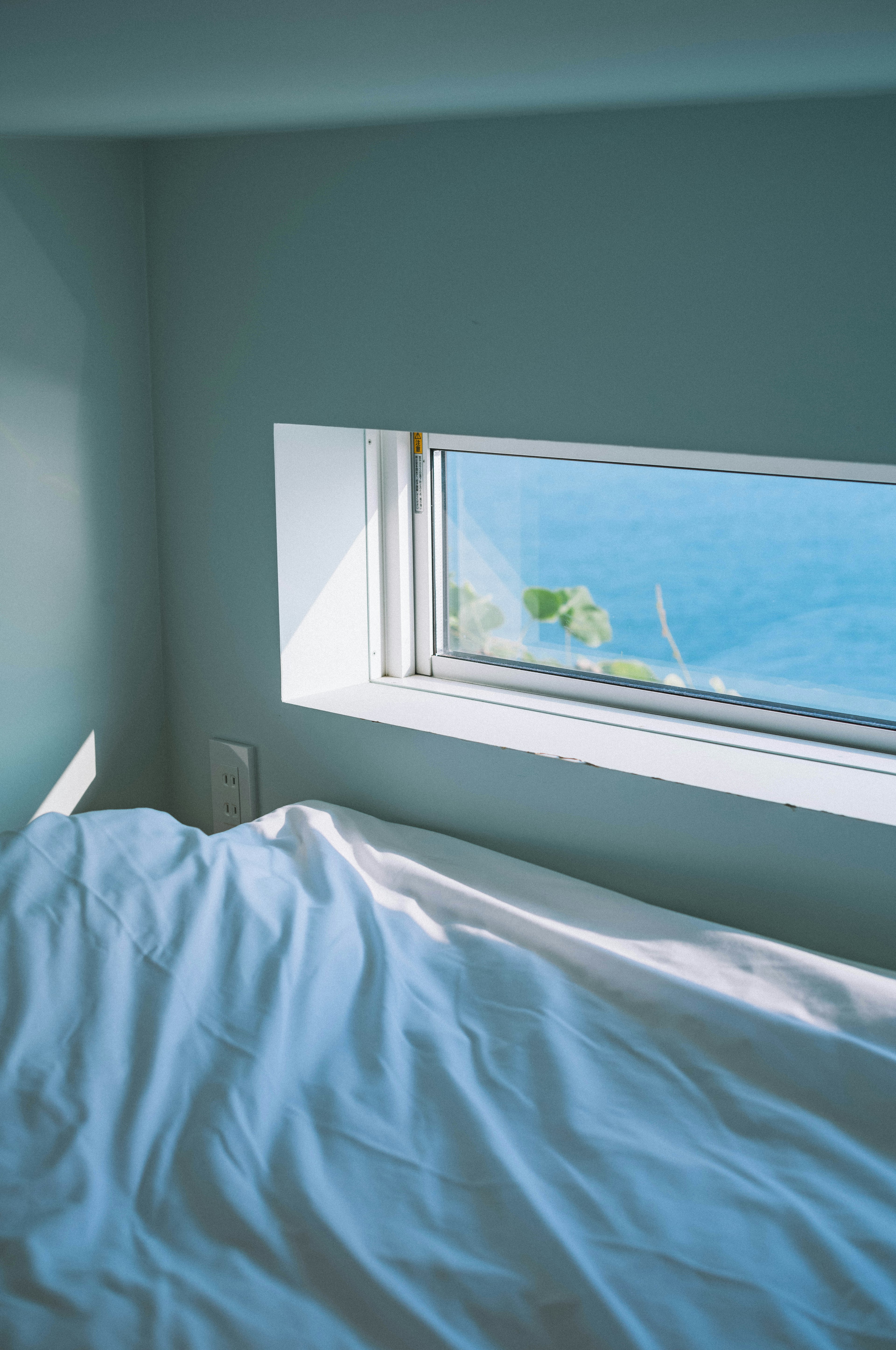 Schlafzimmer mit Blick auf den Ozean durch ein Fenster