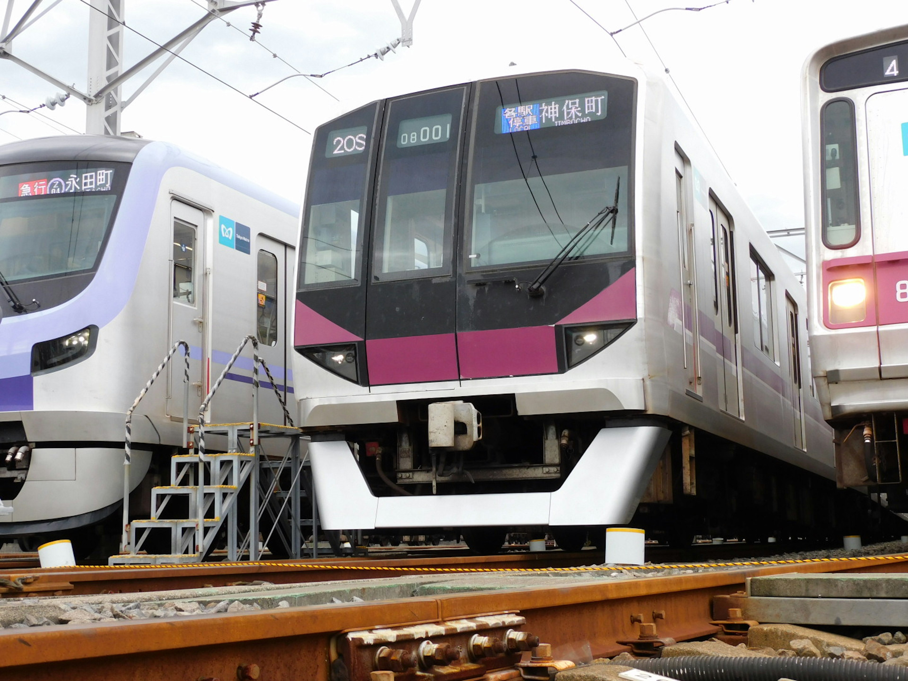 A modern train with a sleek design parked on the tracks