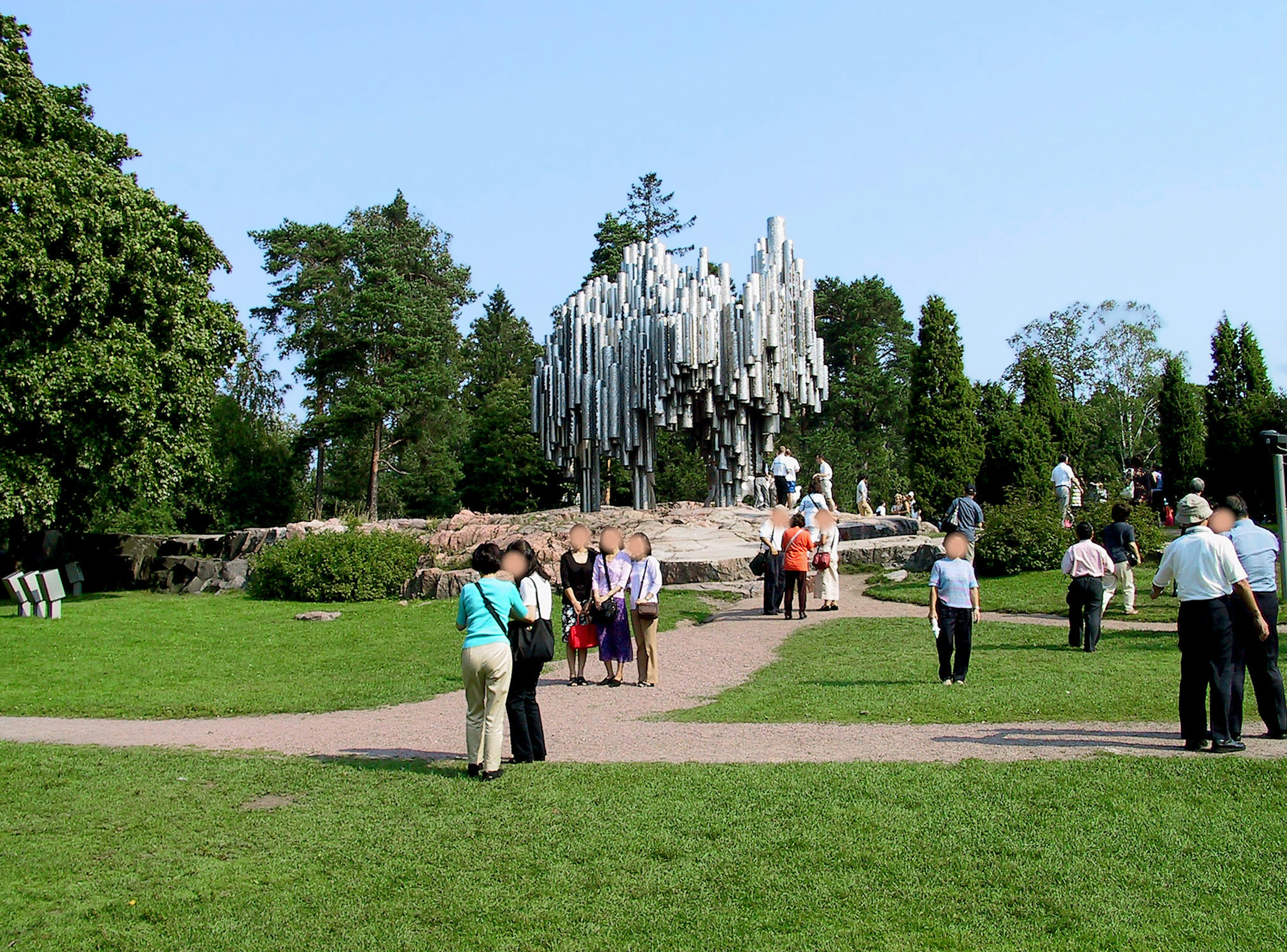 人們聚集在公園裡靠近一座大型抽象雕塑