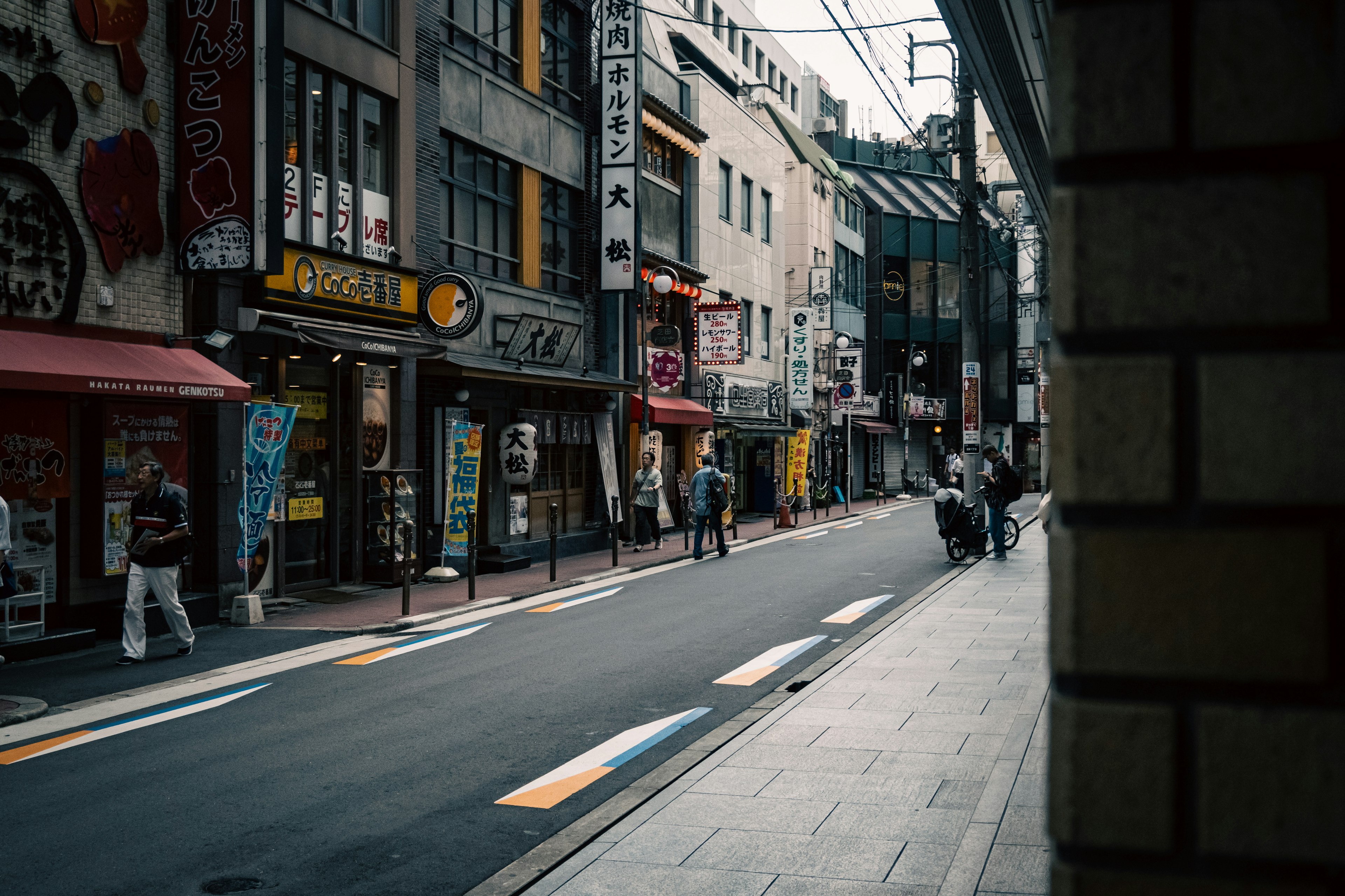 Quiet streetscape featuring shops and pedestrians