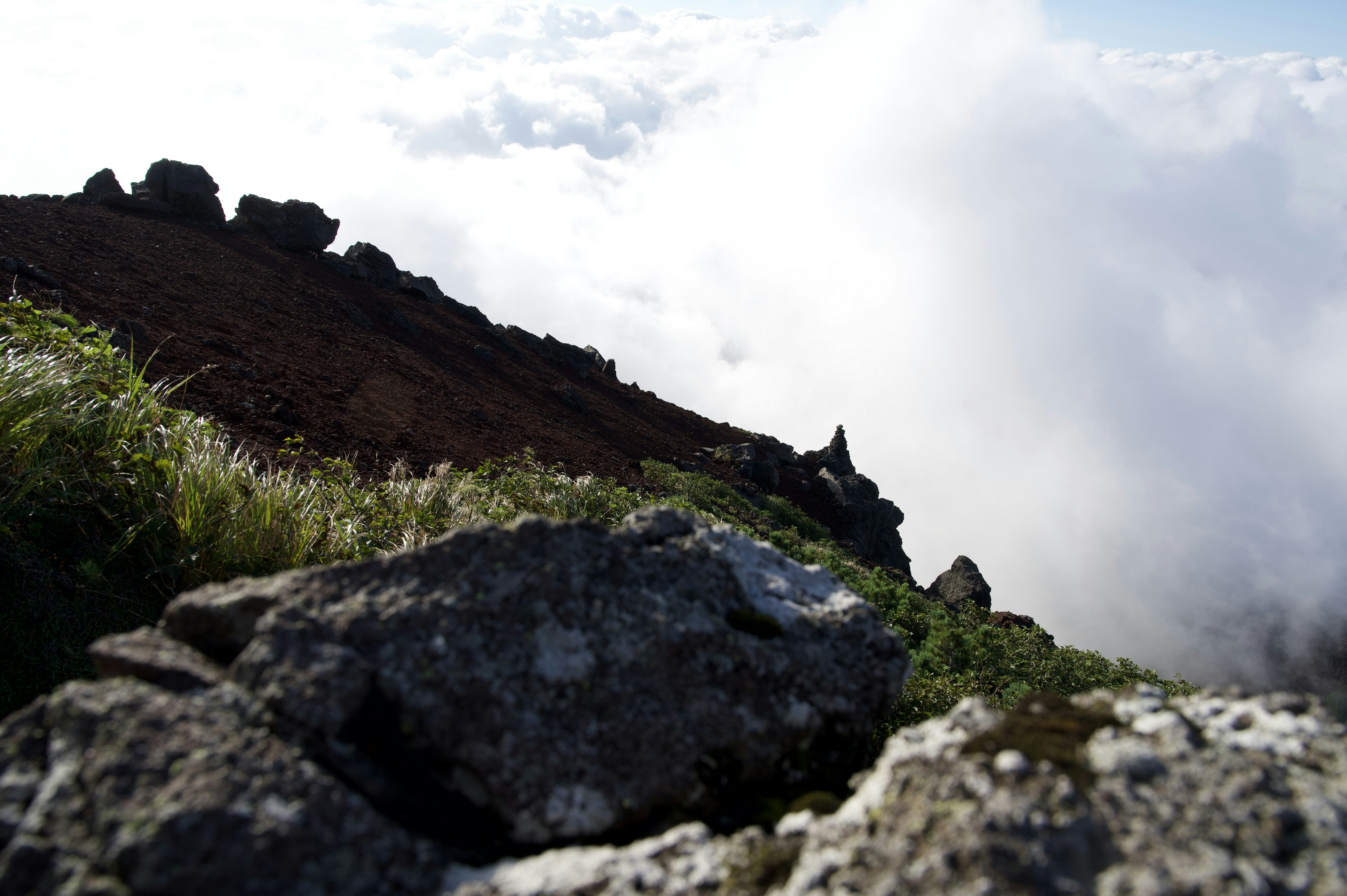 Malersicher Blick vom Berggipfel mit felsigem Gelände und Wolken