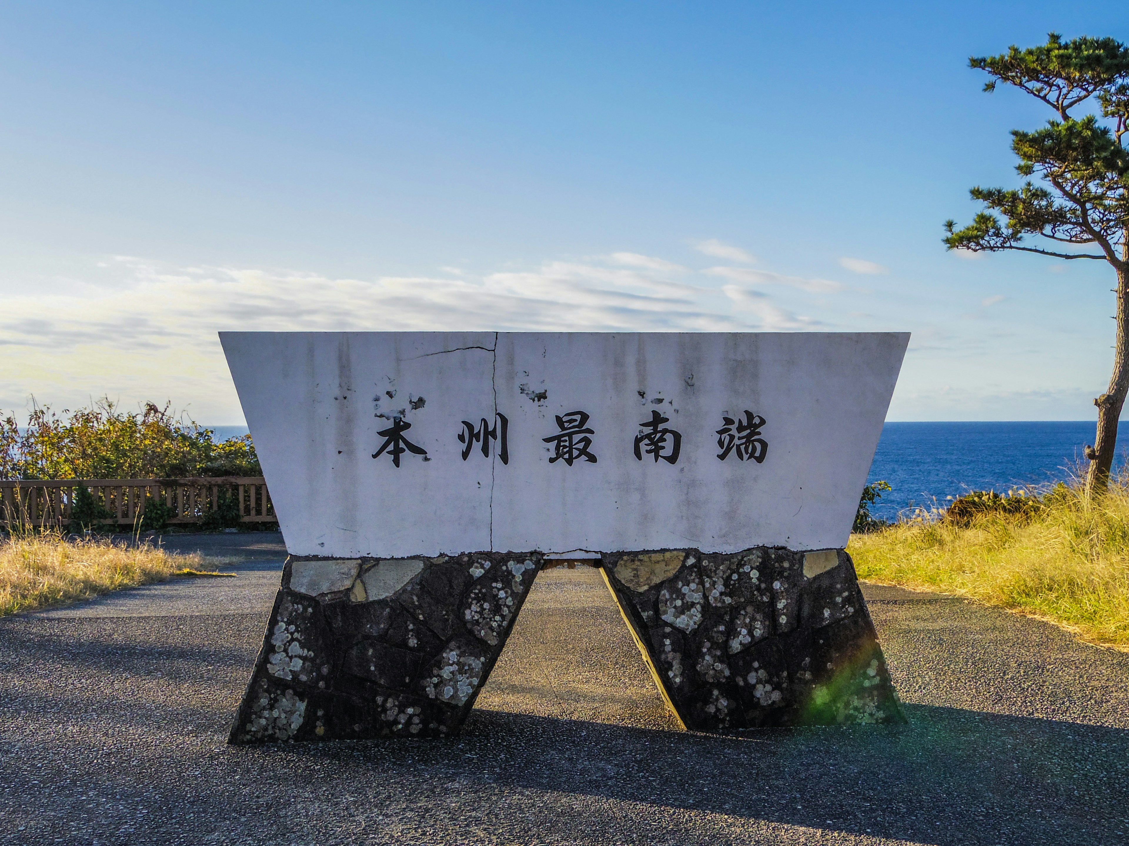 White stone monument with Japanese characters near the ocean