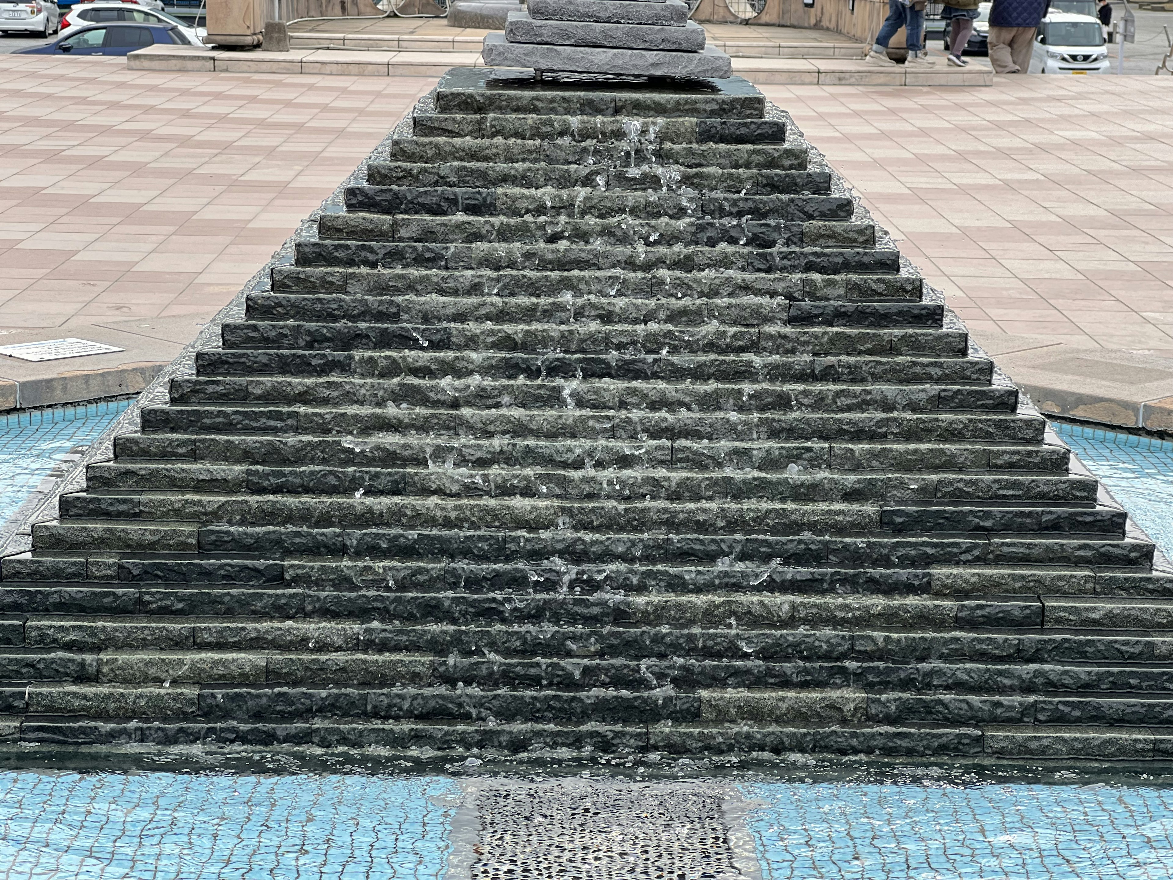 Fontaine en pierre en forme d'escalier avec de l'eau qui coule