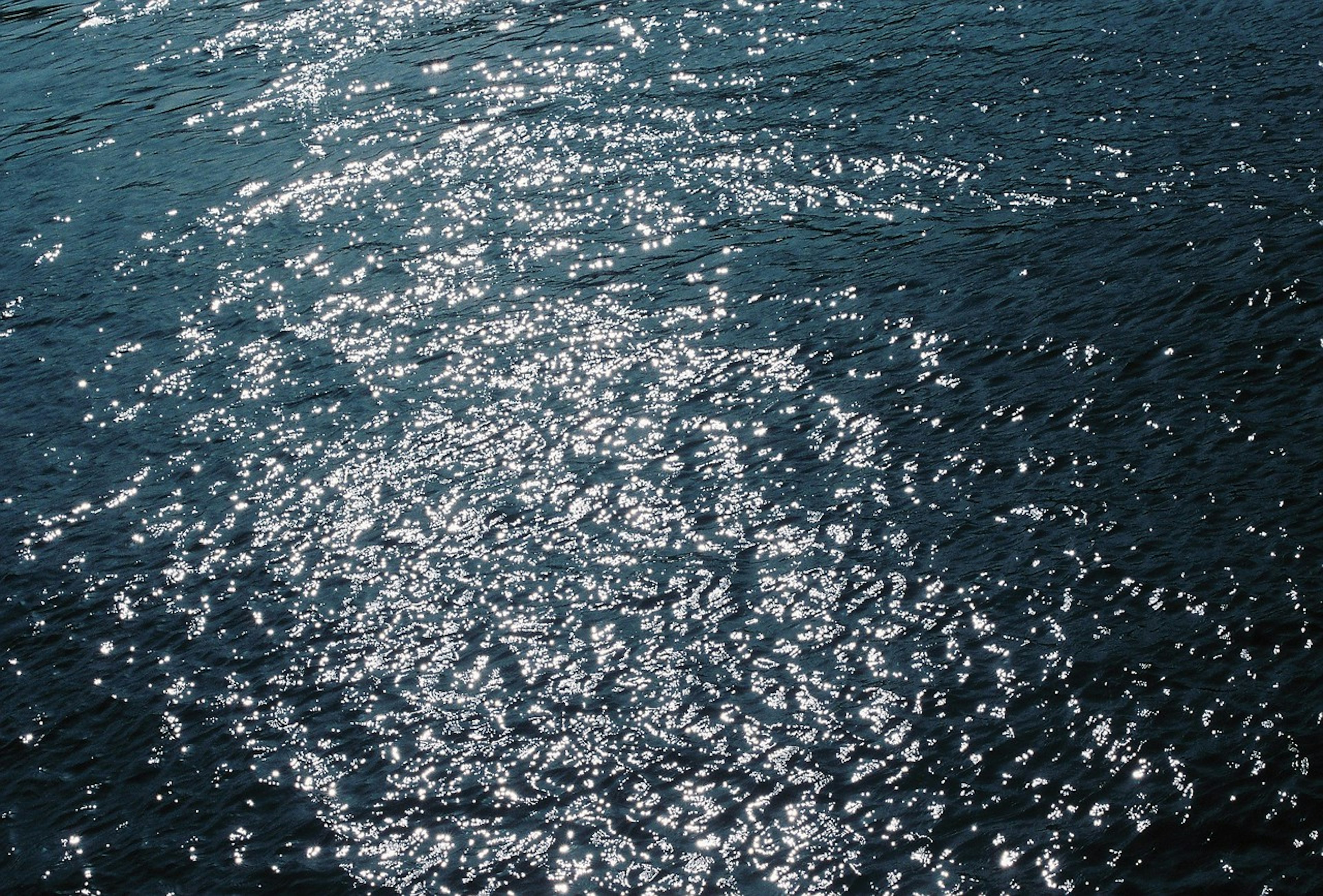 Shimmering reflections of light on dark blue water