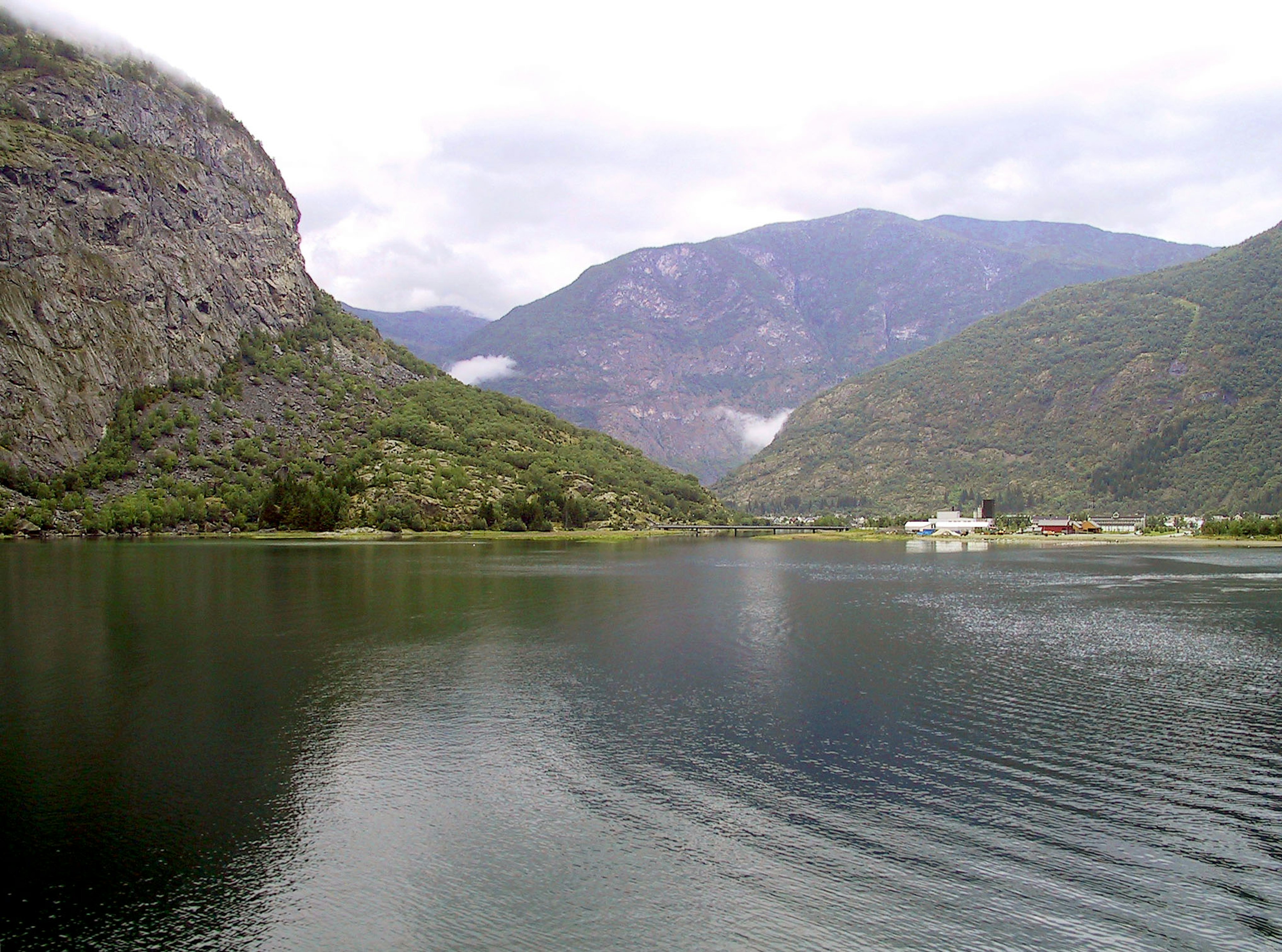 Vista escénica de un lago tranquilo rodeado de montañas