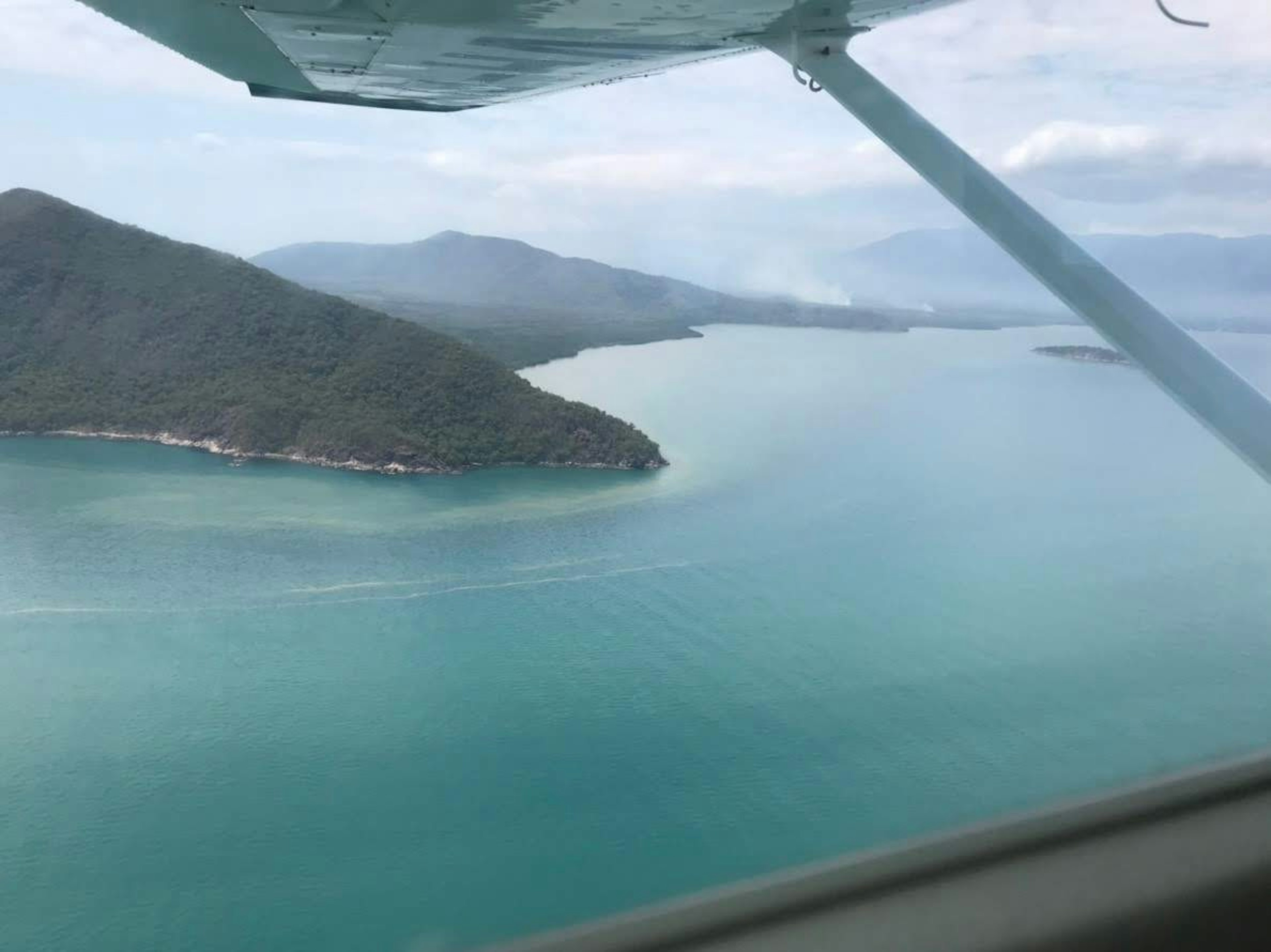 Pemandangan laut dan gunung dari jendela pesawat