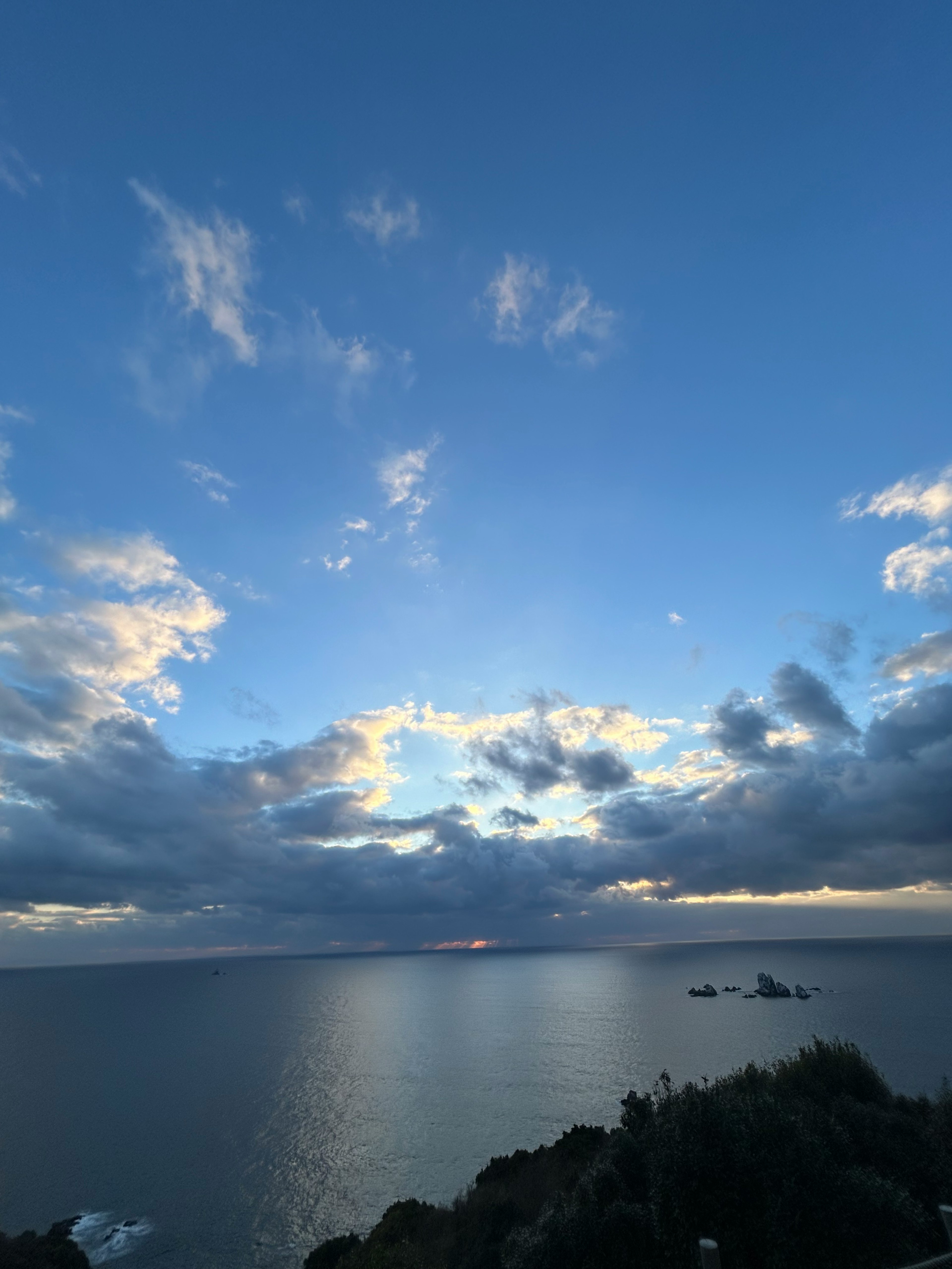 Pemandangan laut di bawah langit biru dengan awan