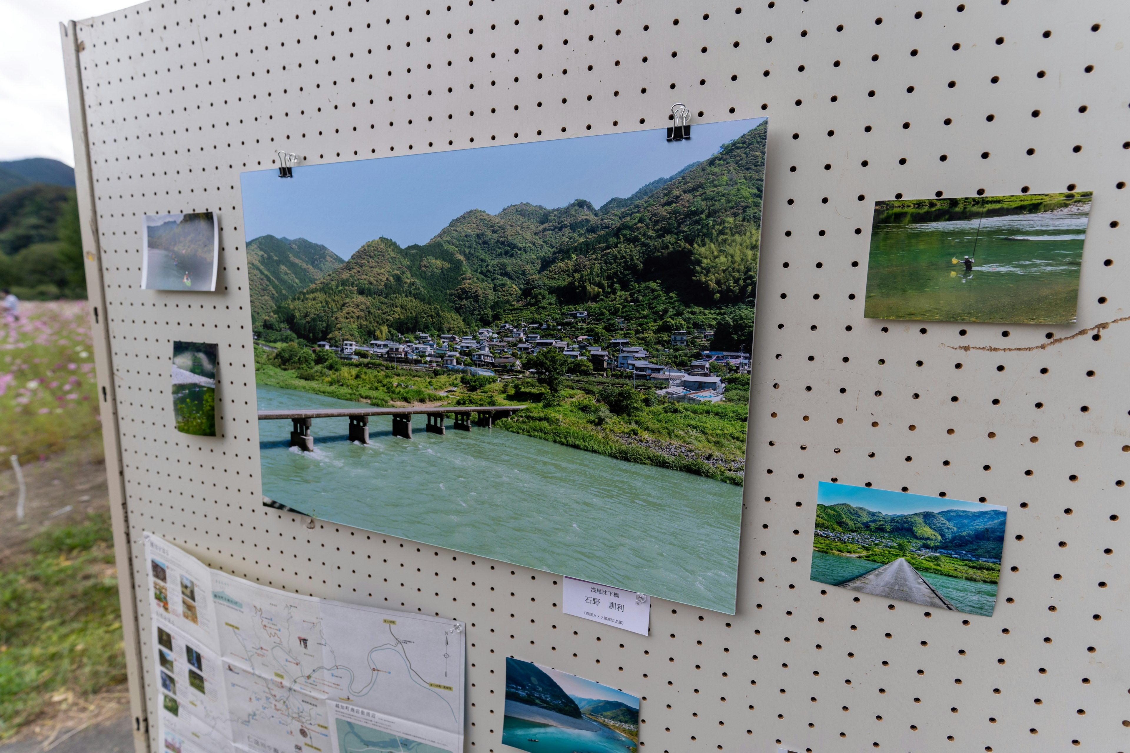 青い川と山に囲まれた村の風景が展示されている