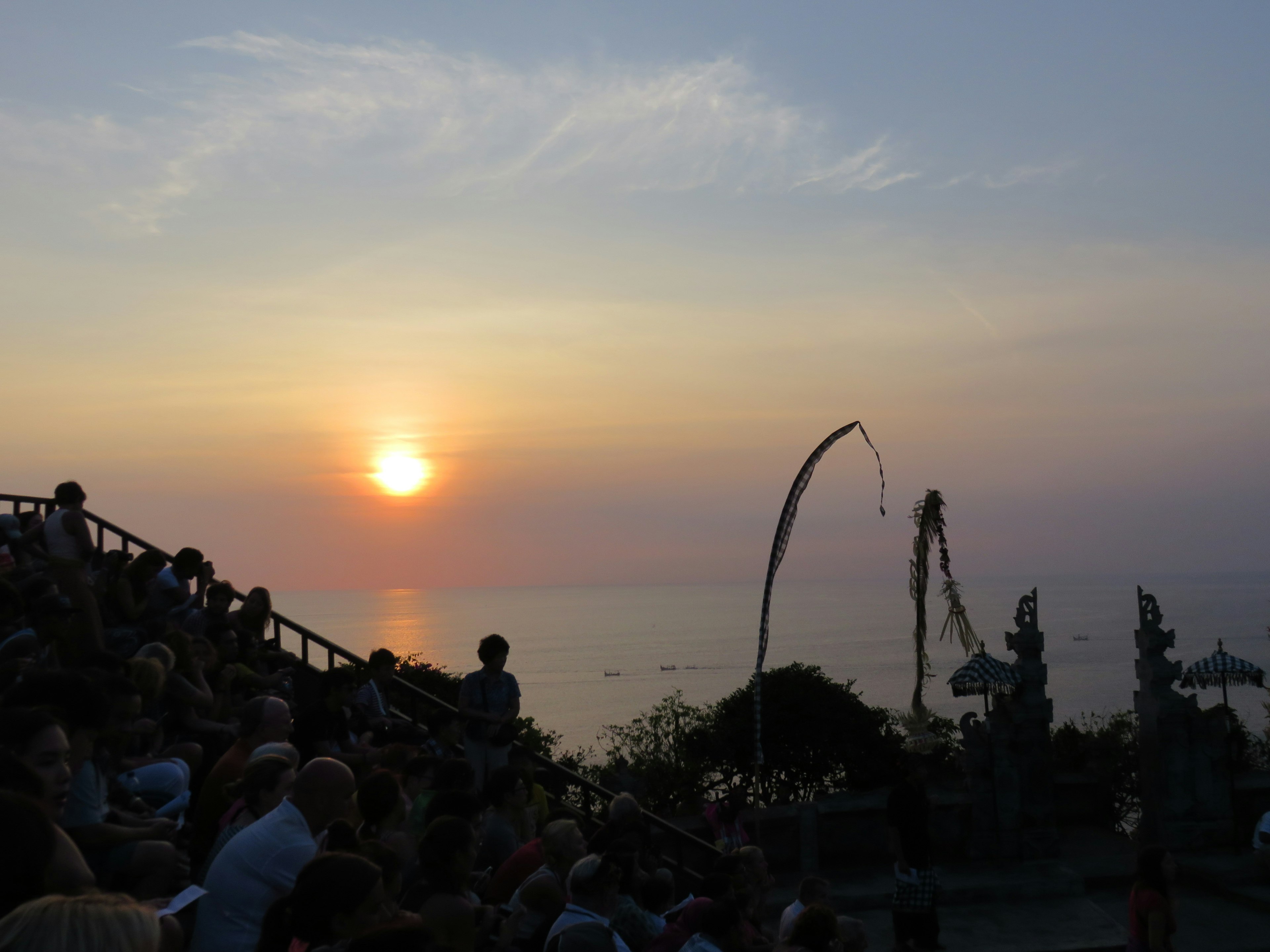 Beautiful sunset over the ocean with silhouettes of spectators