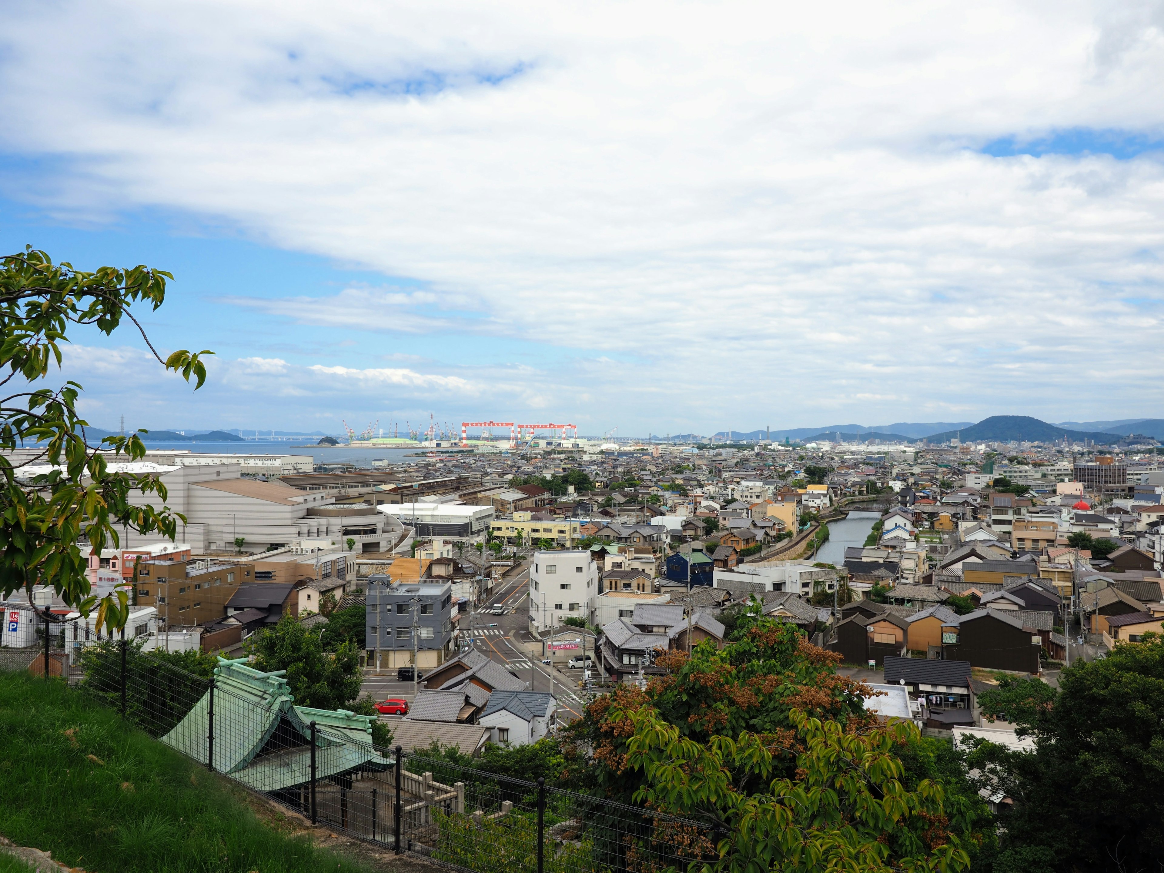 城市的空中视图 绿地和建筑物 明亮的天空和云