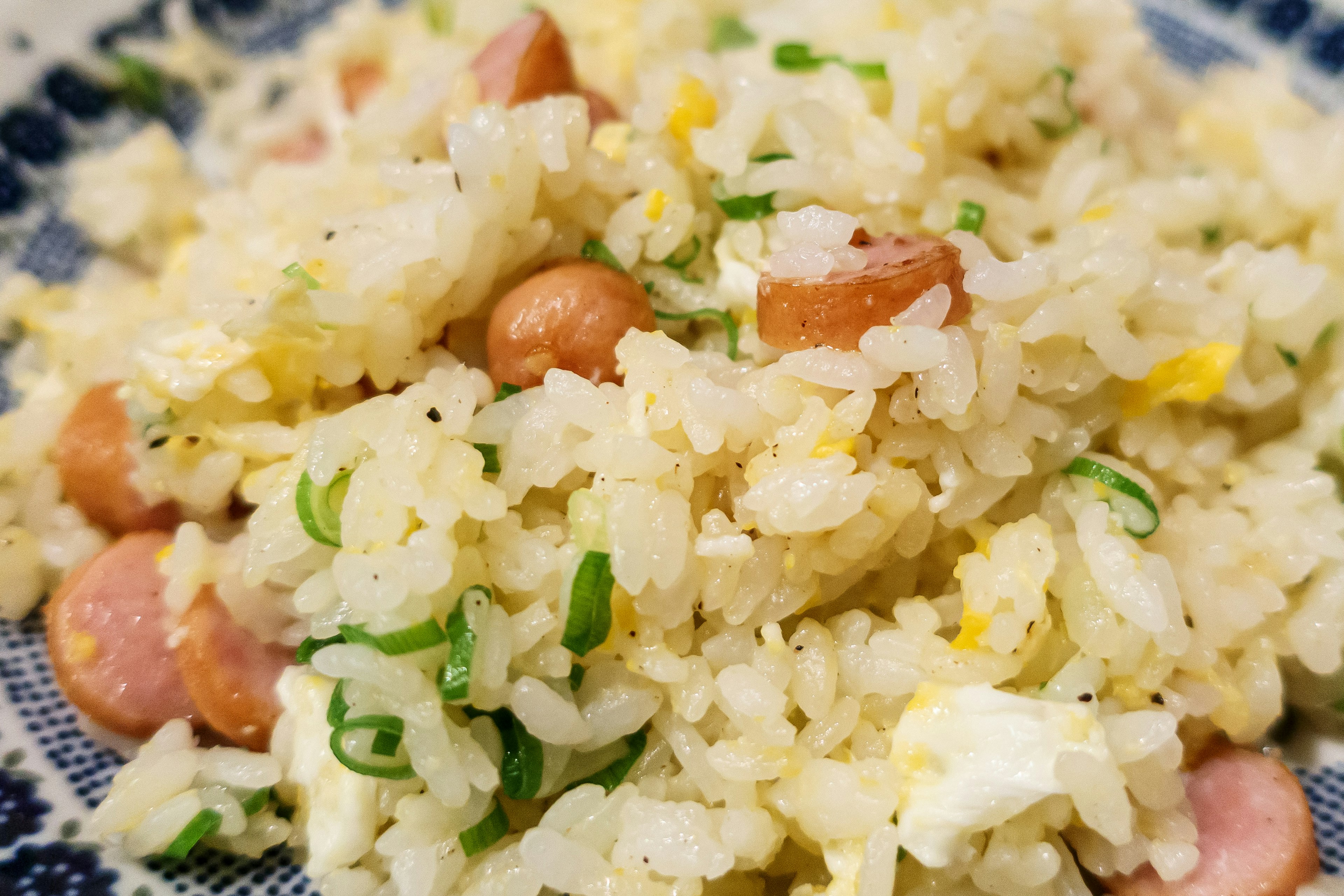 Plato de arroz frito con salchichas y huevos revueltos