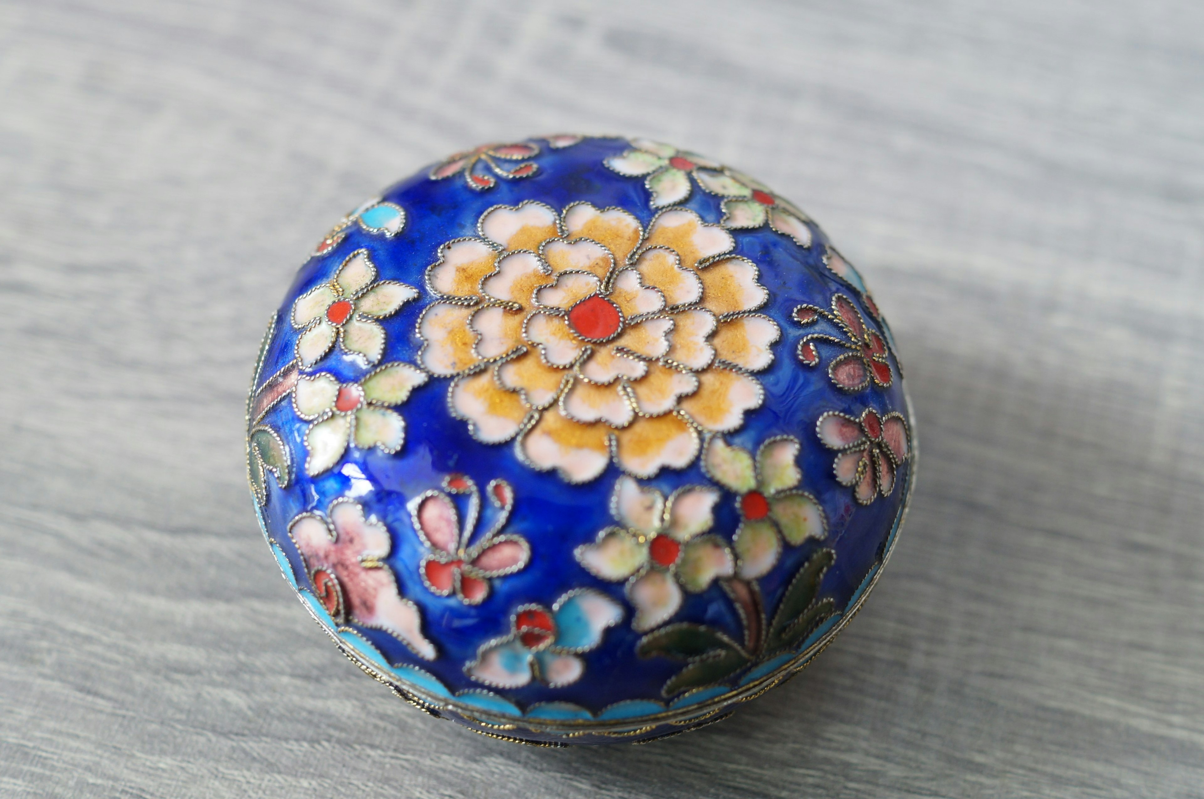 青い背景に花模様が描かれた丸い装飾品