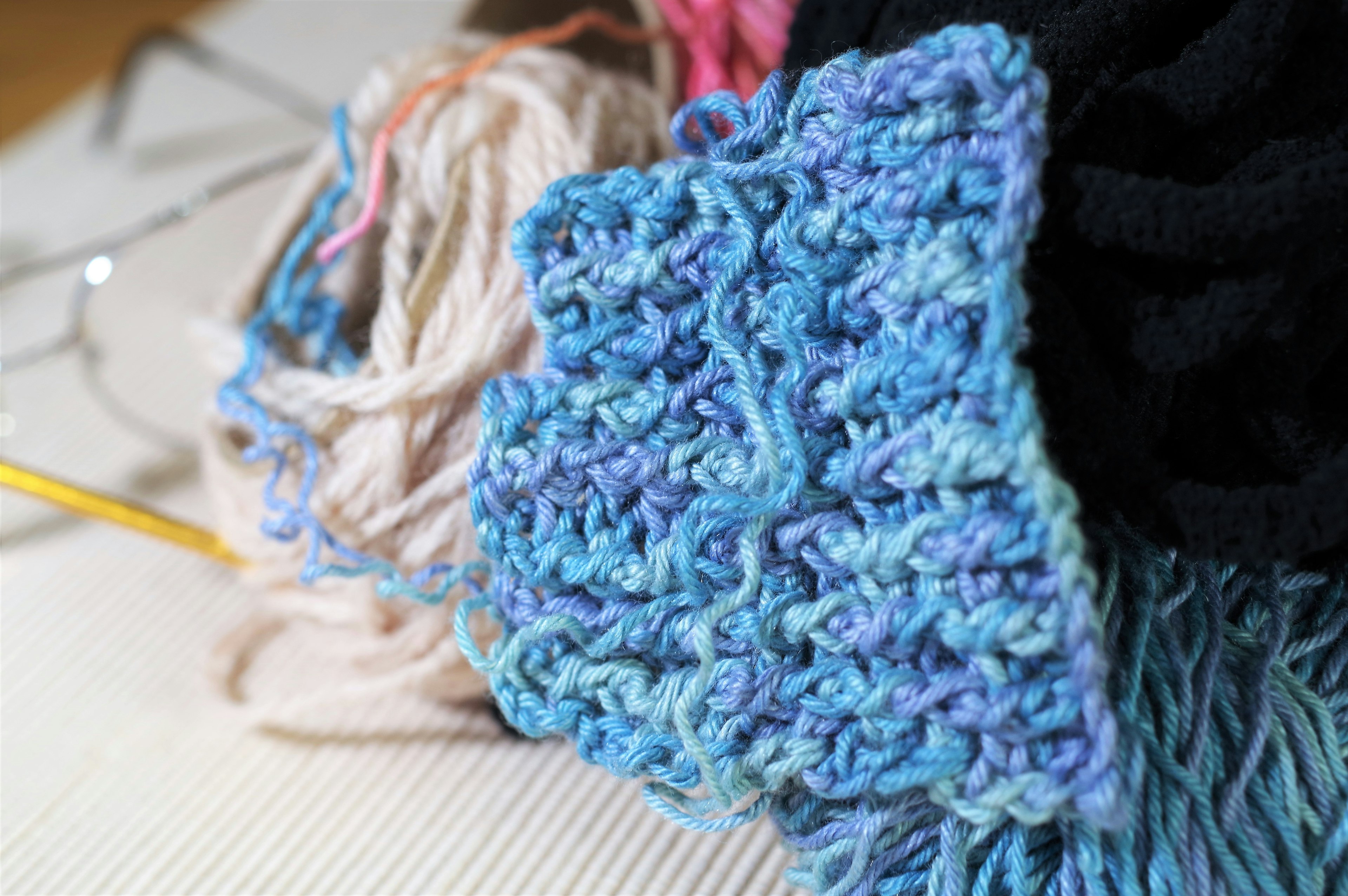 Image featuring a mix of yarn materials with a blue knitted piece