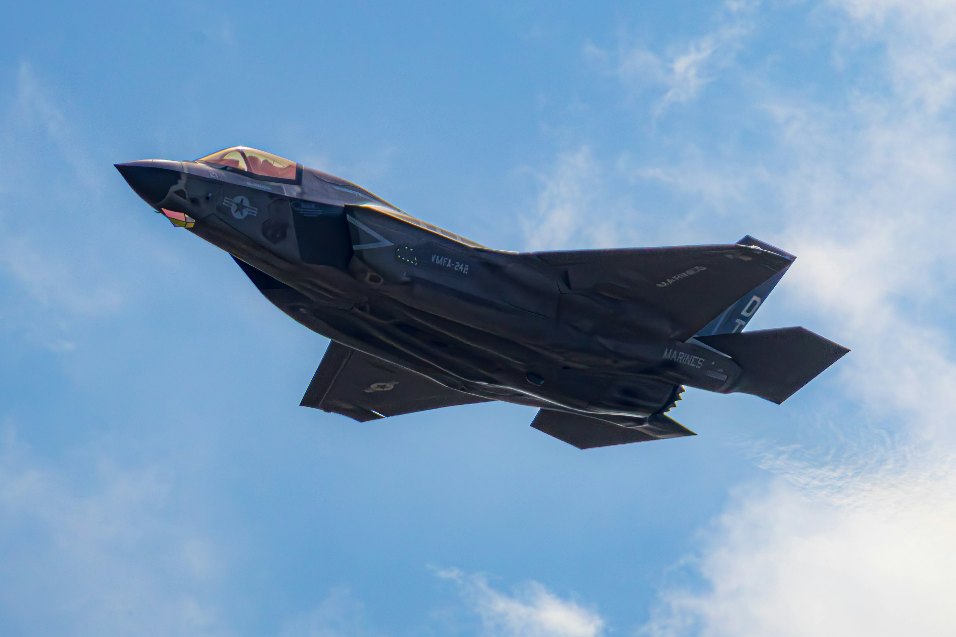 F-35 fighter jet flying against a blue sky