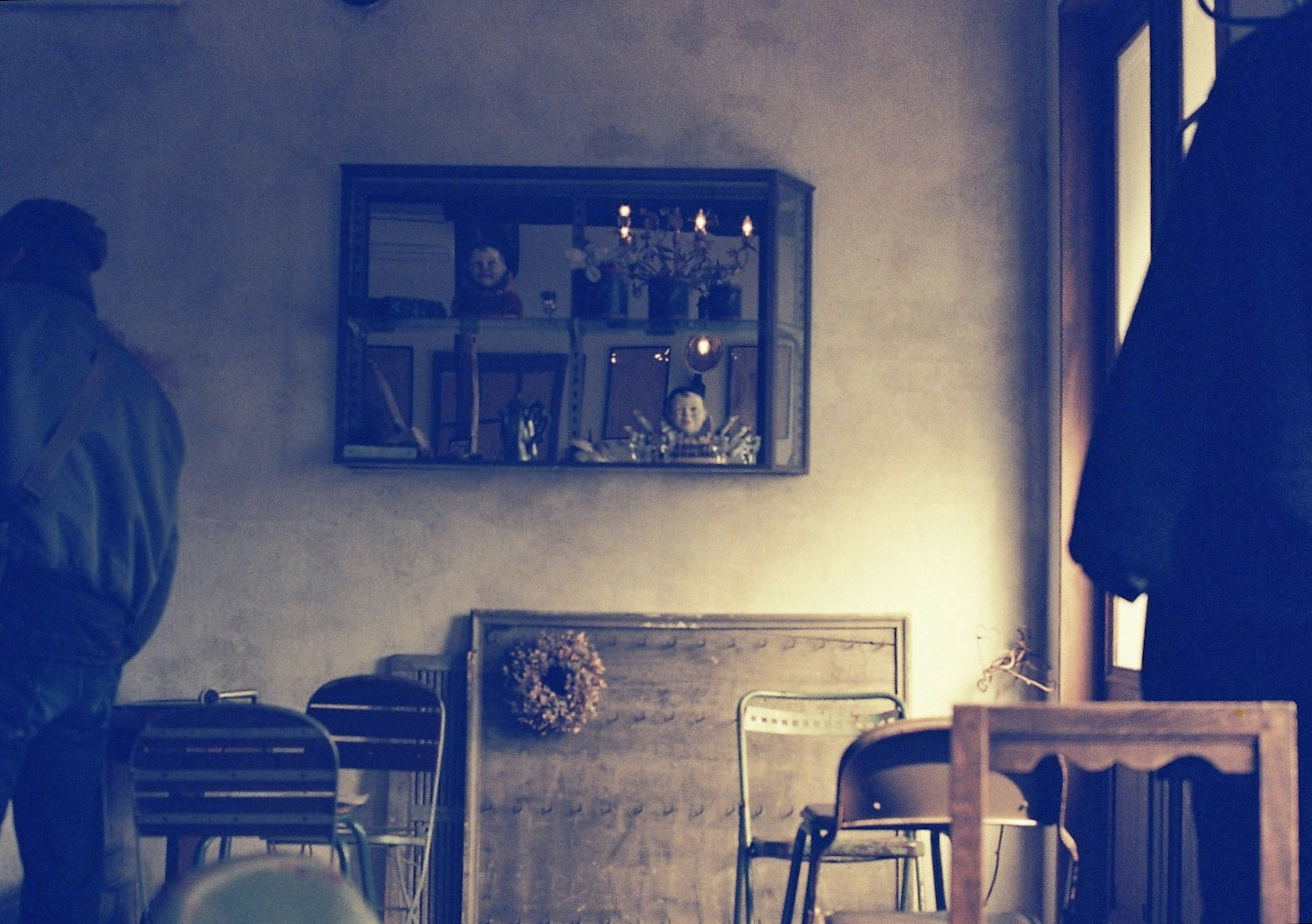 Scène intérieure calme avec des chaises en bois et une table un miroir et des bougies sur le mur