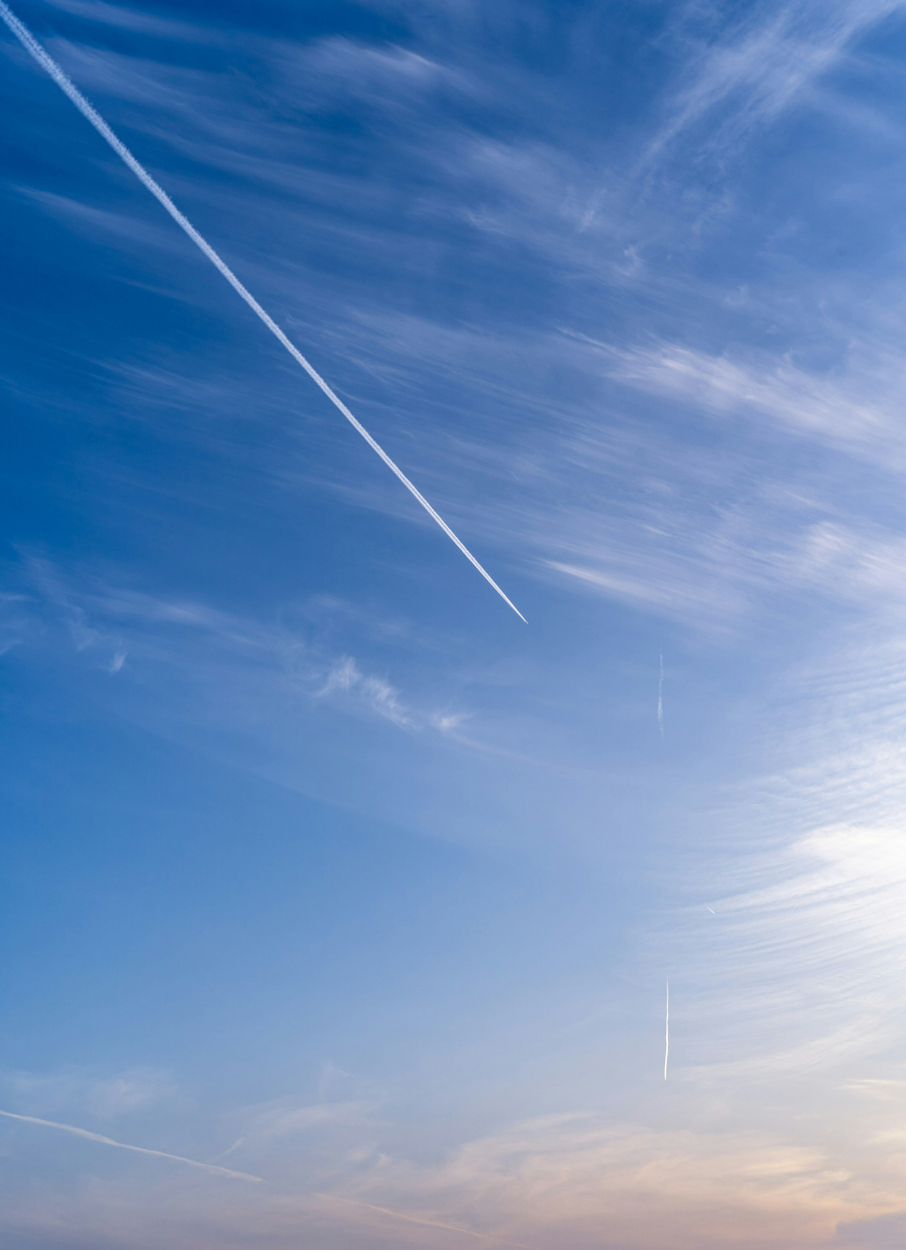 青空に飛行機雲が描く白い線