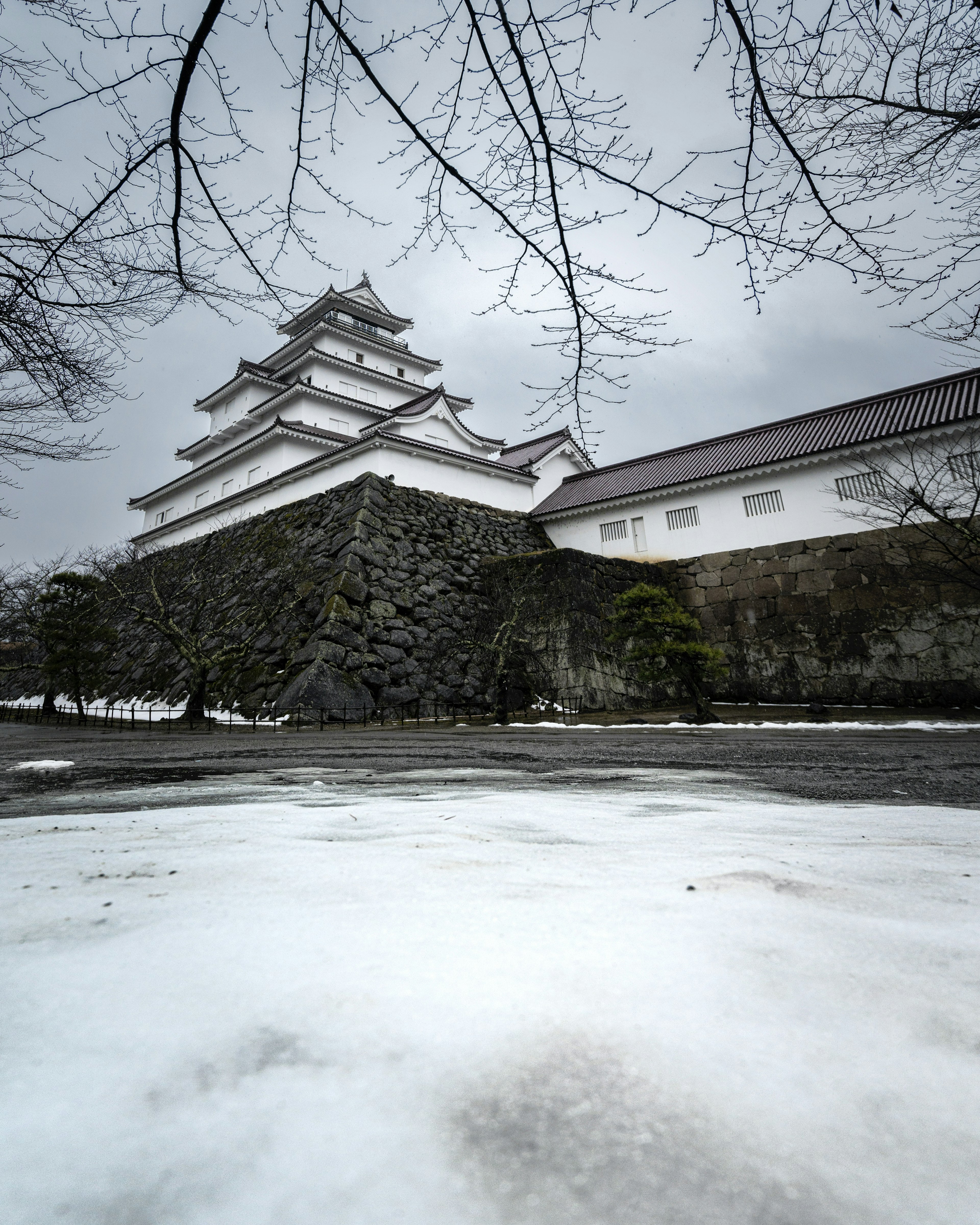 Exterior del castillo cubierto de nieve con cielo gris