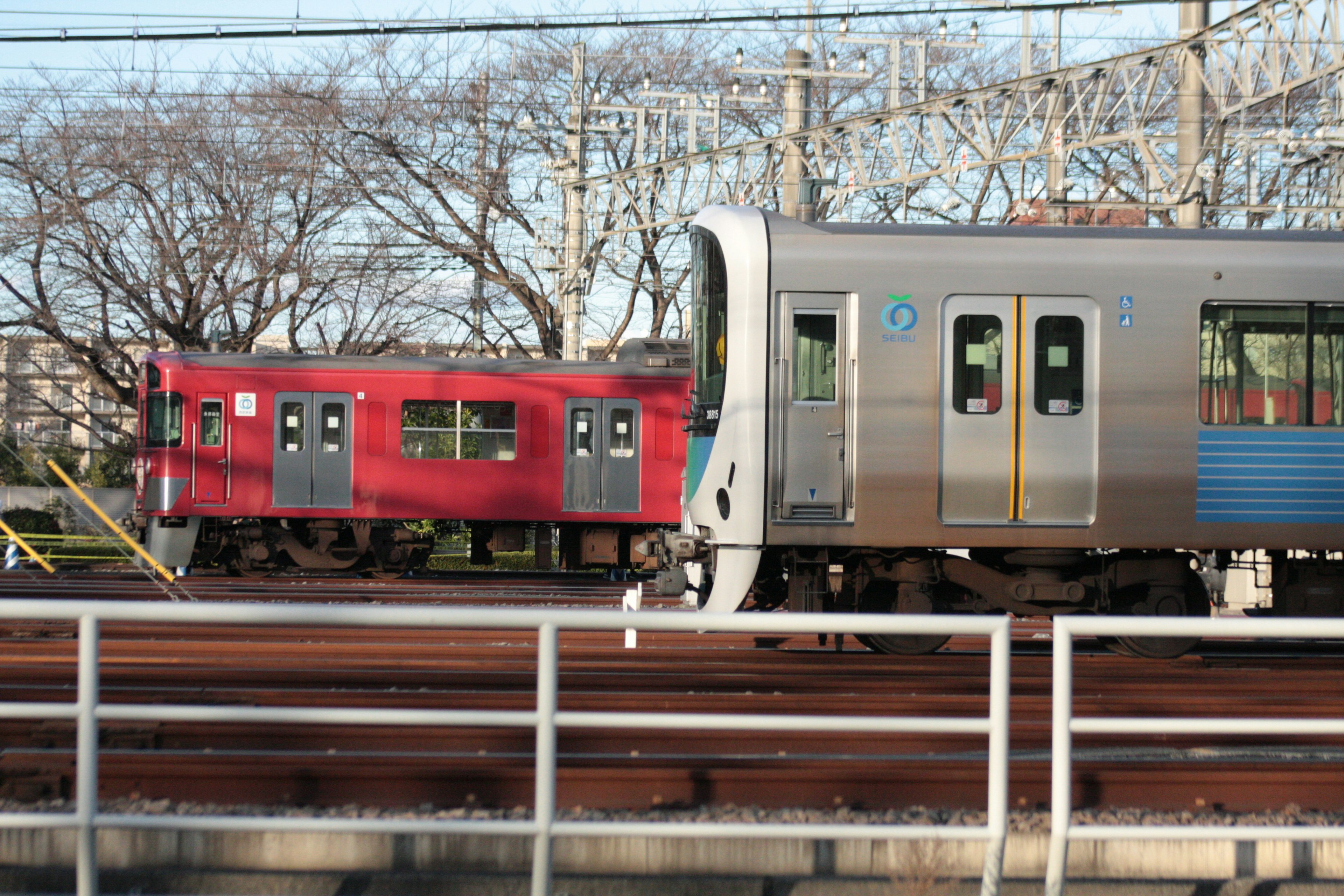 รถไฟสีแดงและสีเงินอยู่ข้างกัน