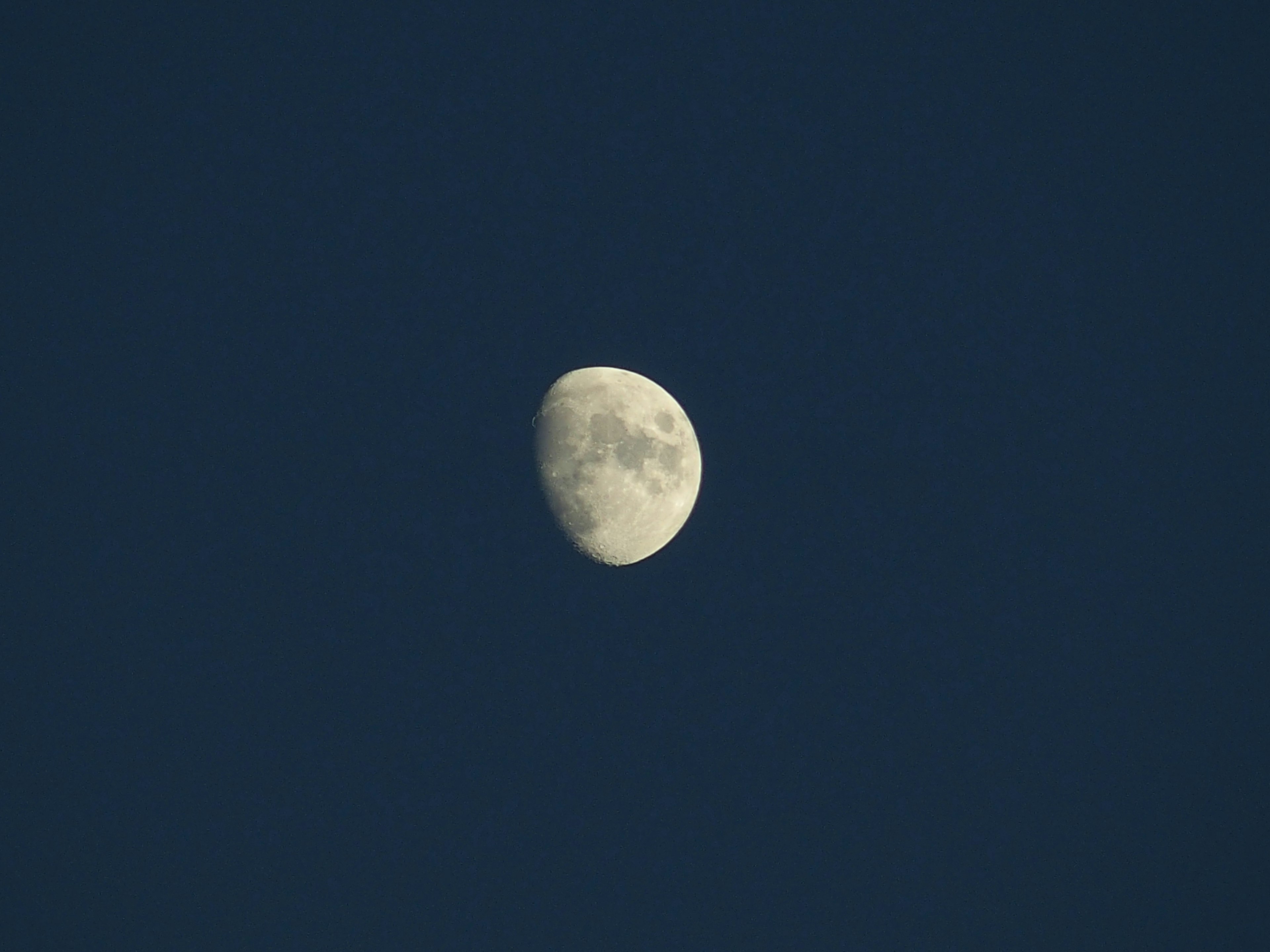 Lune brillante en demi dans un ciel bleu